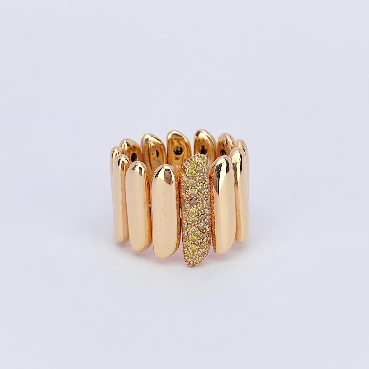This 18 karat rose gold ring is designed with shiny rose gold motifs that are approximately 18mm wide. The center motif is set with pave yellow diamonds. The band type ring is opened in the back allowing for expansion. Fits size 6-9. Matching