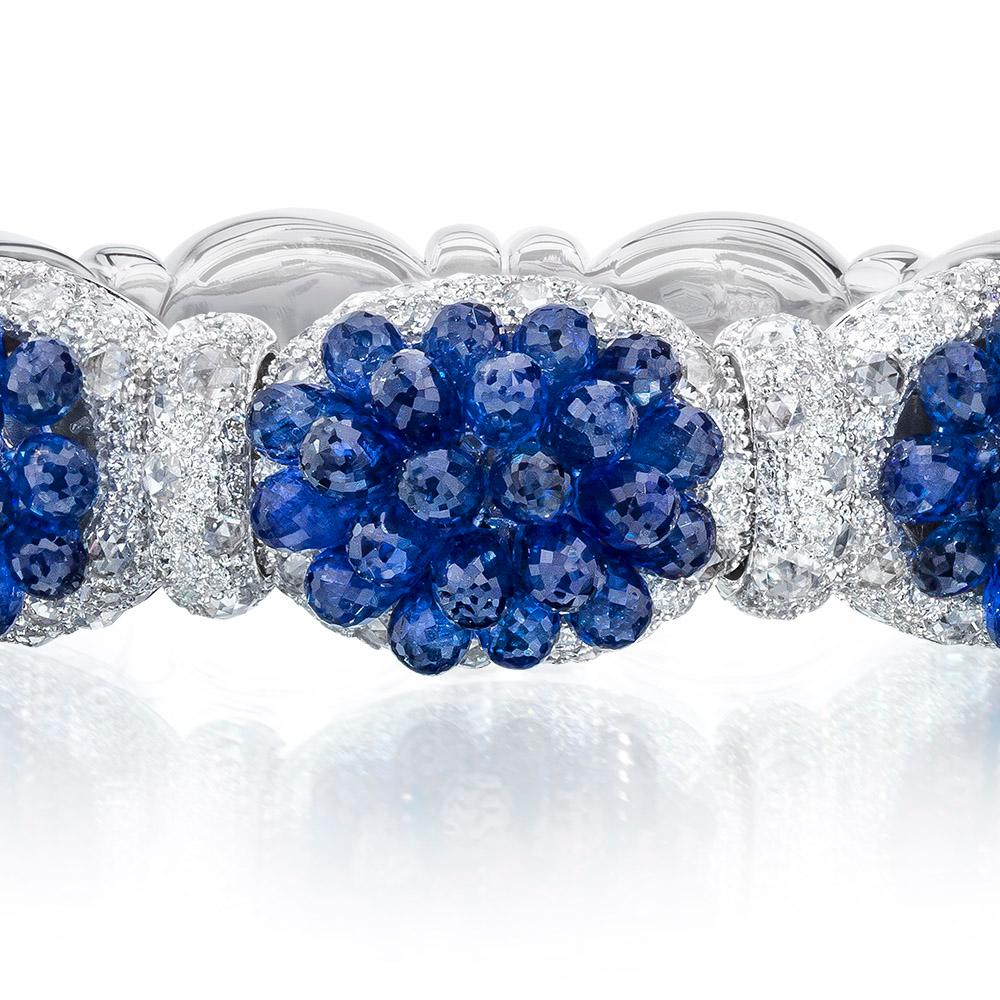 This unique and fun bangle was handcrafted in Italy by renowned jewelry designer Verdi exclusively for Cellini Jewelers. This piece is composed of 4.74 carats of rose-cut and brilliant cut diamonds which surround three sections of 37 carats of blue