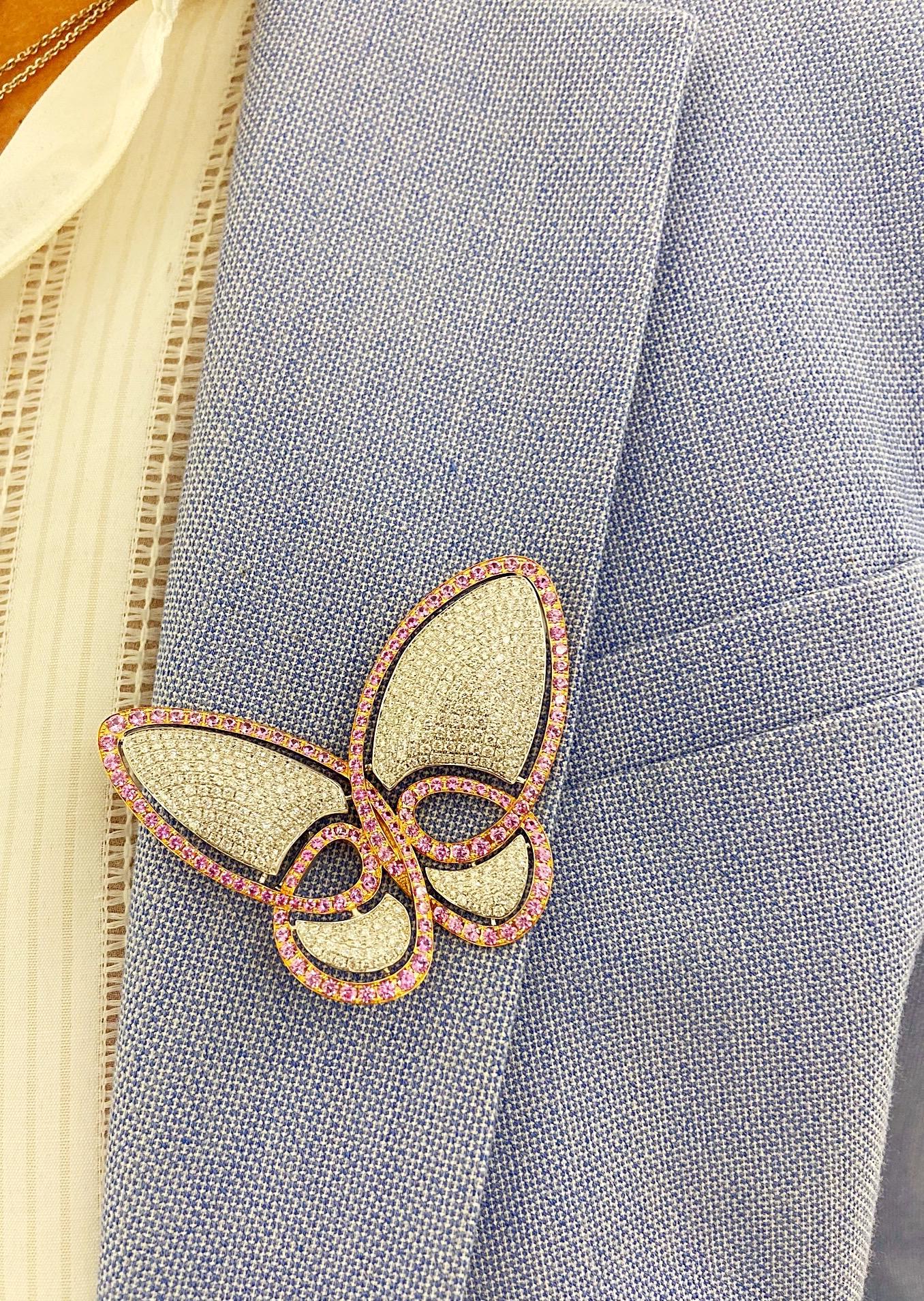 This lovely 18 karat white gold butterfly brooch is impeccably pave set with Round Brilliant Cut Diamonds . The outer trim of the butterfly is 18 karat rose gold set with Round Brilliant Cut Pink Sapphires. The brooch measures 2.5