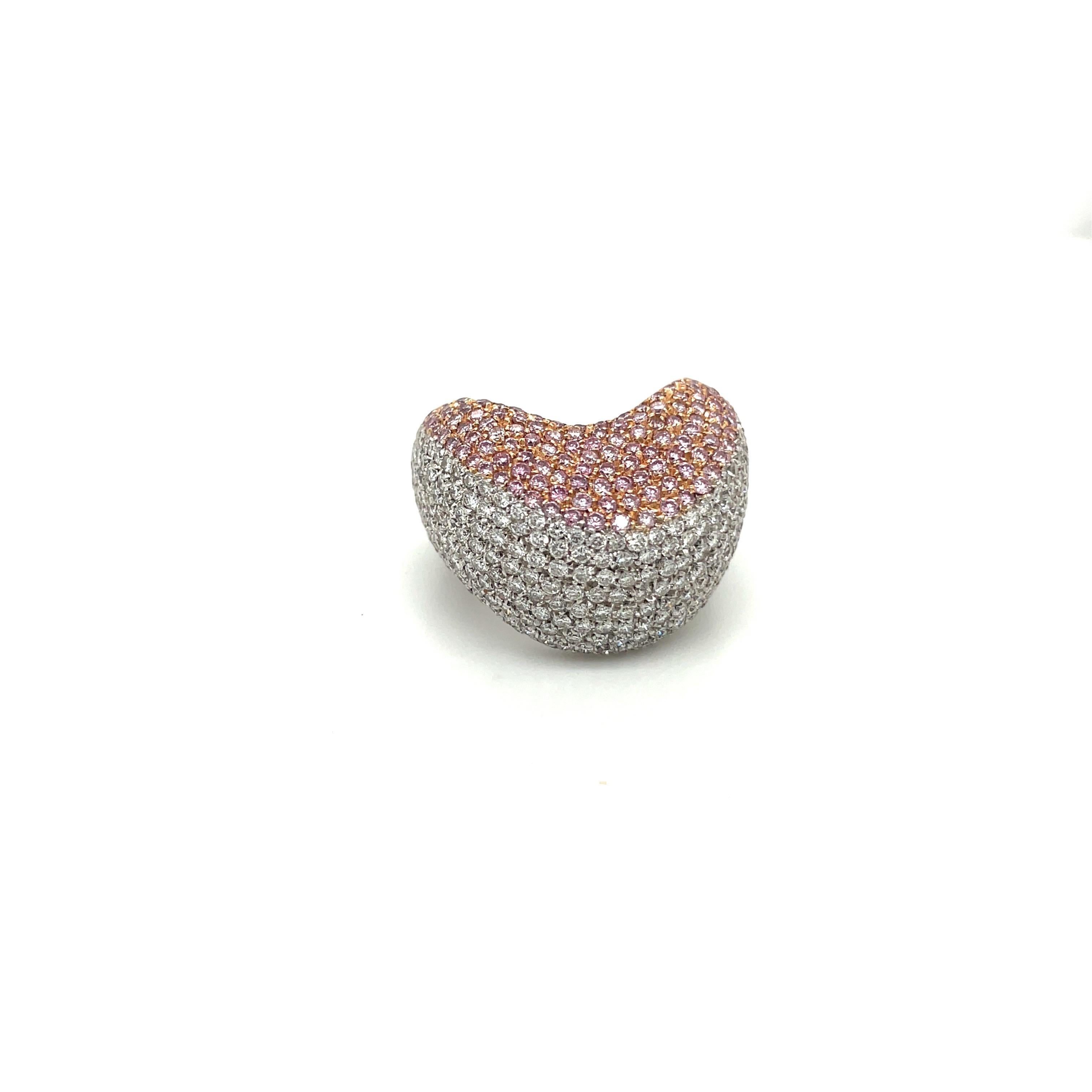 Des diamants naturels roses et blancs sont sertis en pavage dans cette bague sculpturale en forme de dôme. Réalisée en or blanc et en or rose 18 carats, cette bague élégante se porte confortablement sur le doigt.
Poids total des diamants roses =1,19