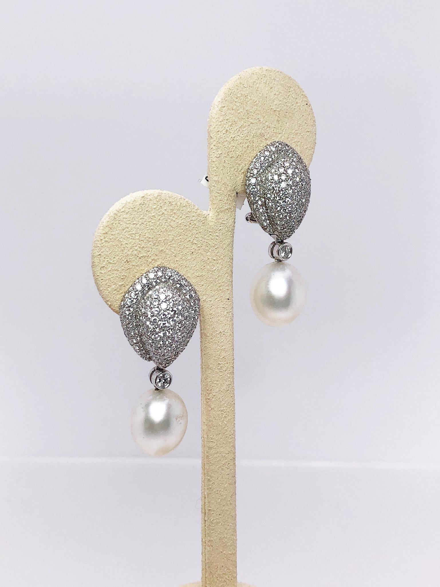 Cellini Jewelers NYC 18KT White Gold earrings, are composed of 3.91 carats of diamonds and 14.5mm X 12mm South Sea Pearls. Approximately 300 round diamonds make up the beautiful bombe design. 
Earrings measure approximately 1.5