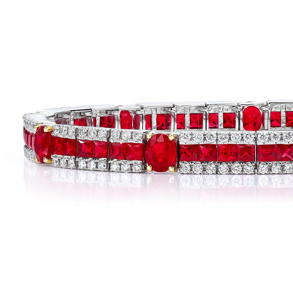 Hand crafted by Cellini Jewelers comes this beautiful line bracelet which is set with 9 oval rubies and 54 french cut rubies., totaling  6.29 carats. The bracelets border is set with round brilliant white diamonds weighing 2.02 carats.
The bracelet
