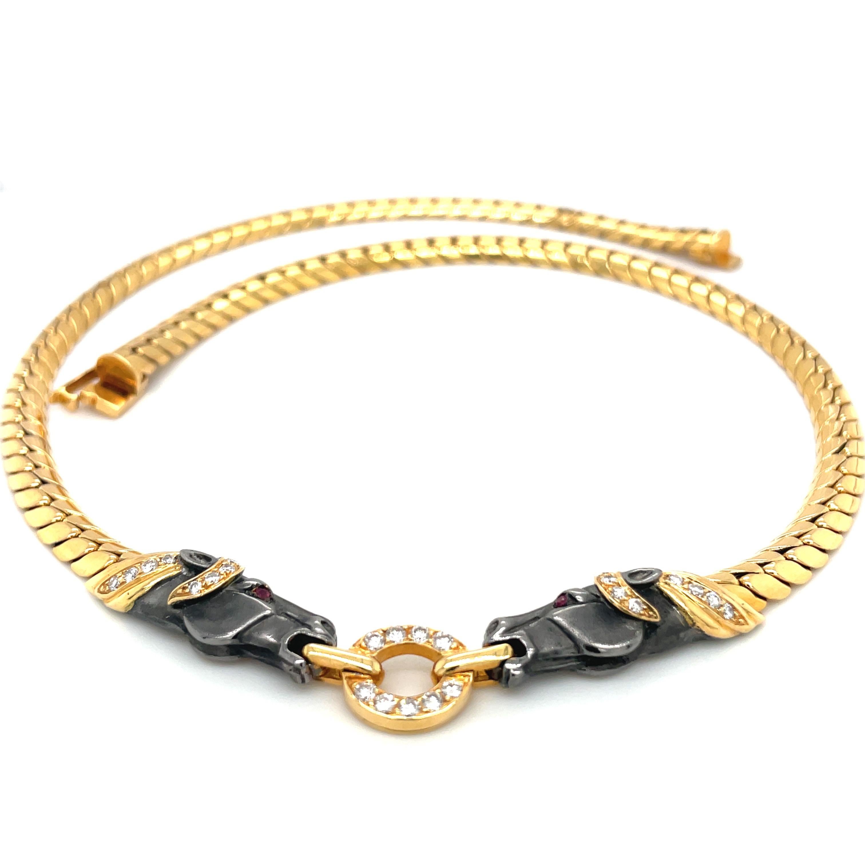 An 18 karat yellow gold choker necklace. The center of the necklace is set with 2 blackened gold horse heads facing each other. Their manes are set round brilliant diamonds as well as the ring they hold in their mouth. Their eyes are set with