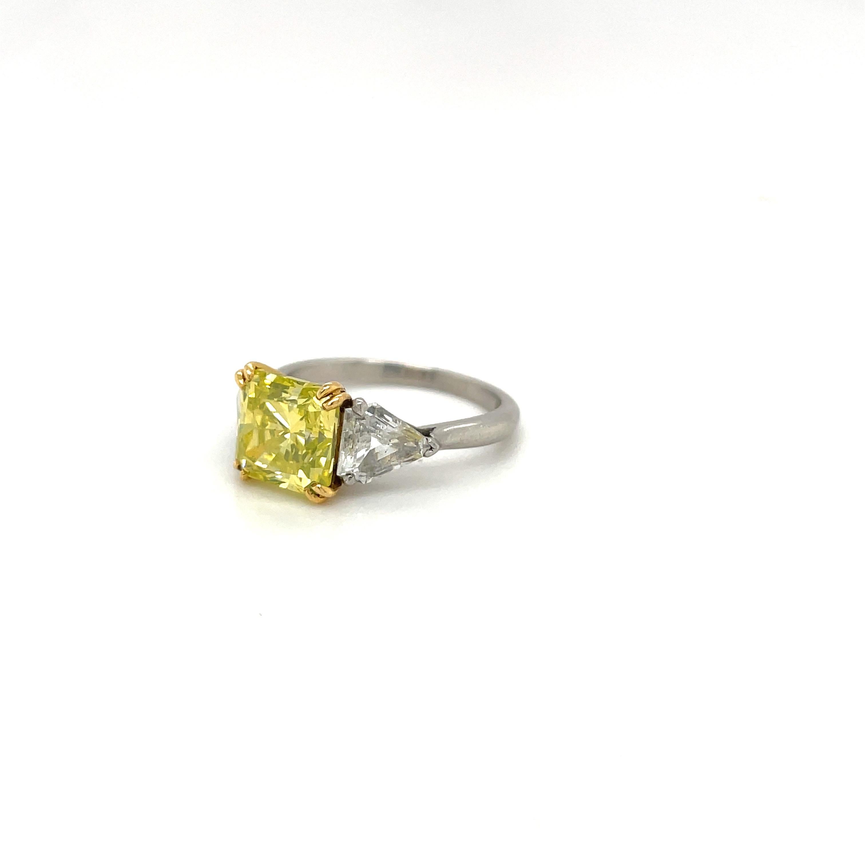 Rare, natural fancy intense green-yellow radiant-cut diamond mounted with kite-cut white diamond side stones. Set in platinum and 18-karat yellow gold.
Center diamond weight: 3.06 carats.
White diamond weight: 0.91cts 
Ring size 6 
Appraisal and