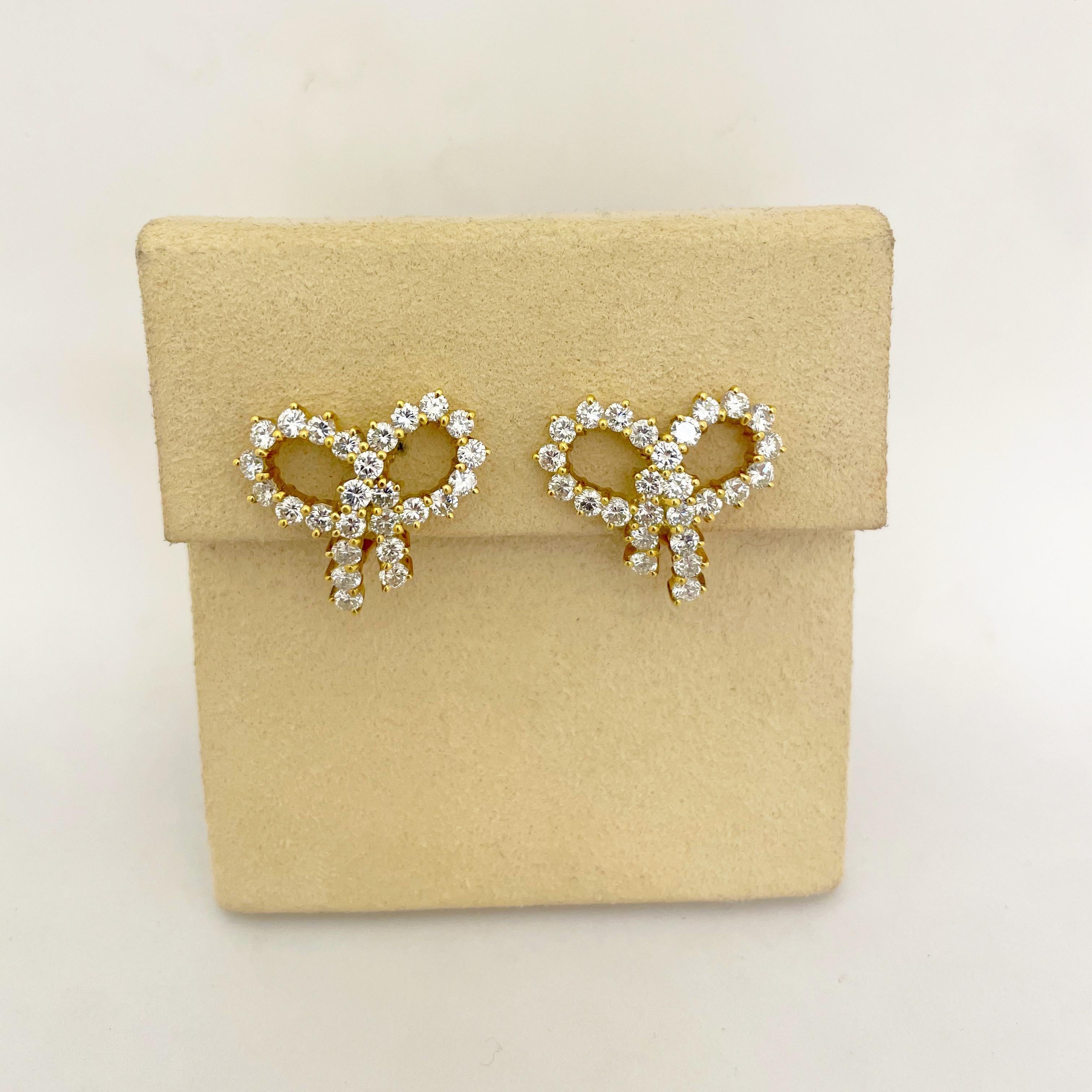 Classic and timeless best describe these 18 karat yellow gold earrings. Round brilliant diamonds ,each in a 3 prong setting form these very feminine bow earrings. The bow measures 1