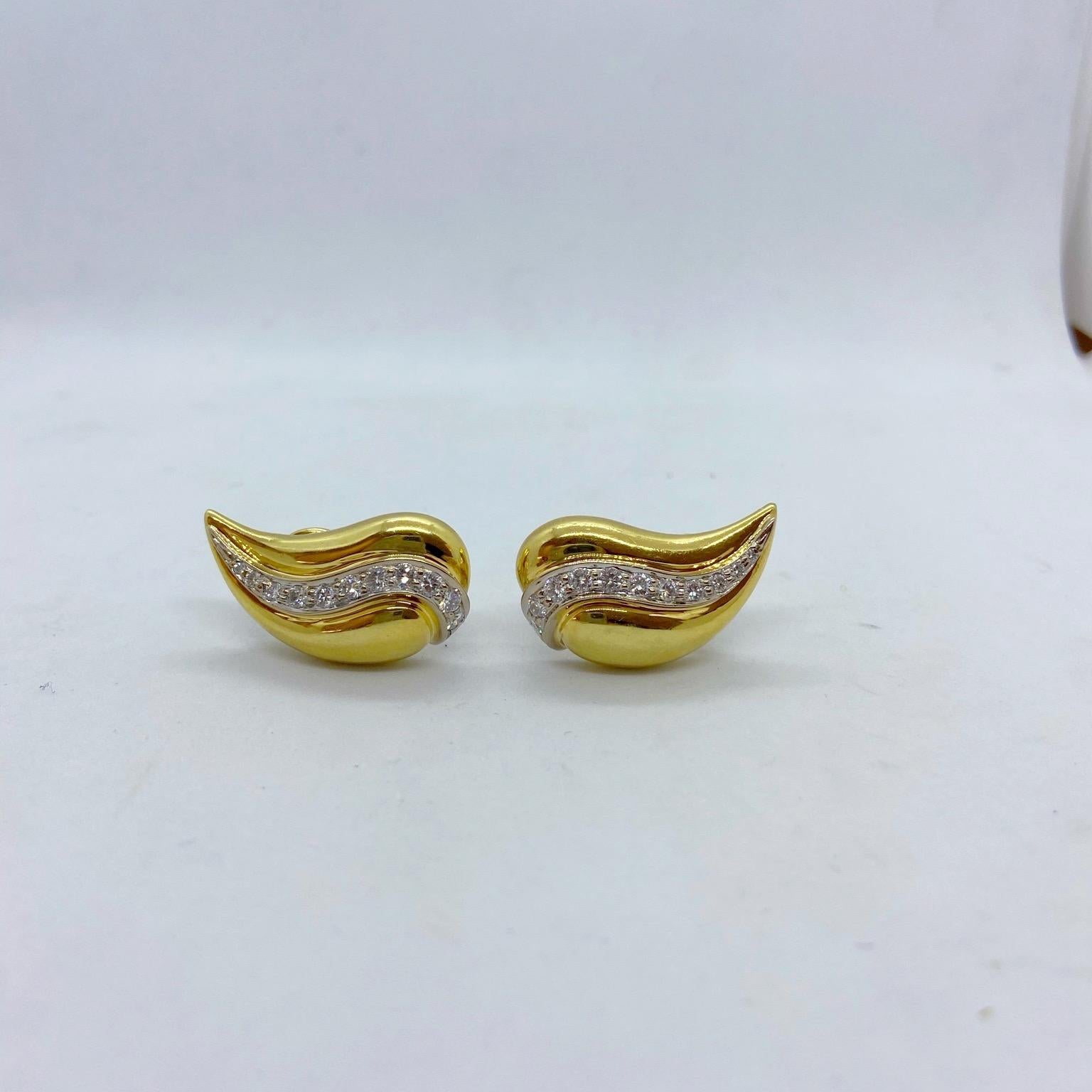 Designed in 18 karat shiny yellow gold, these teardrop shaped earrings center a single row of round diamonds set in white gold. The earrings are clip on , posts can be added. They measure 1-1/8