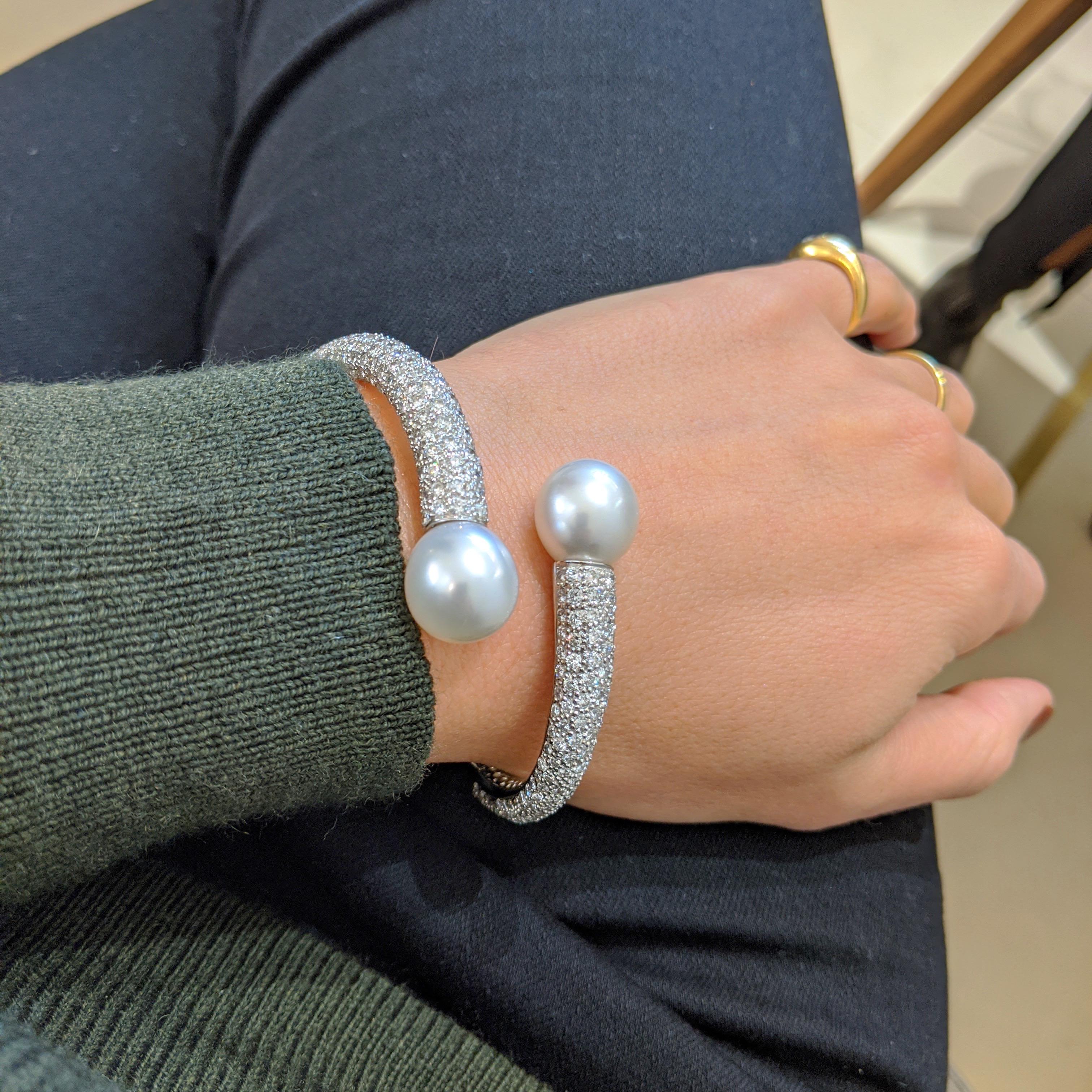 Designed exclusively for Cellini this modern crossover bracelet features 2 matching 13mm white south sea pearls set on pave diamond open bangle bracelet .  The round brilliant diamonds are set 3/4  down. The platinum bracelet is hinged at the bottom