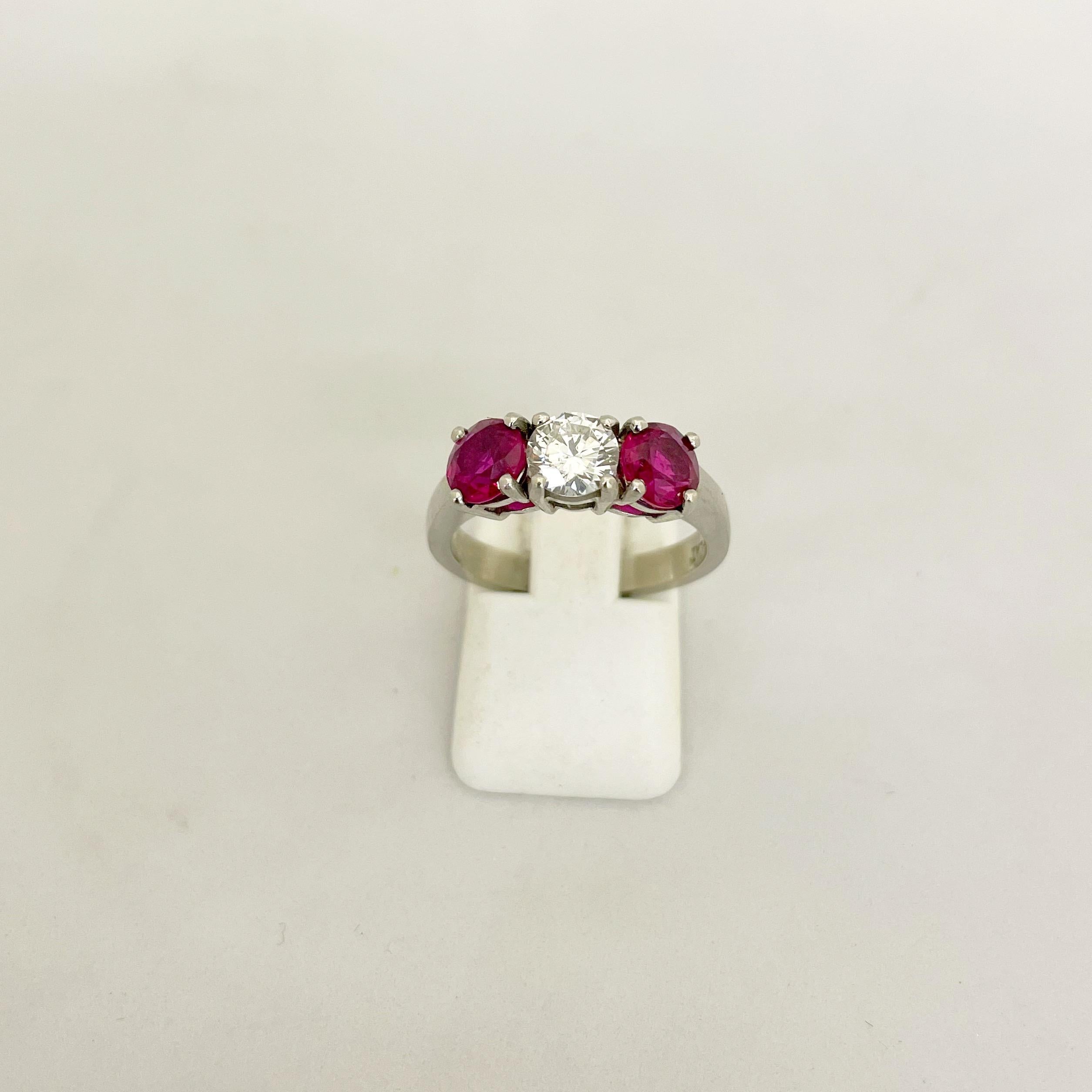 Classic 3 stone platinum ring. This ring centers a round brilliant diamond weighing 0.61 carats. The center diamond is flanked by 2 round brilliant rubies with a total weight of 1.63 carats.
Finger size 6-3/4 sizing available
Appraisal upon request
