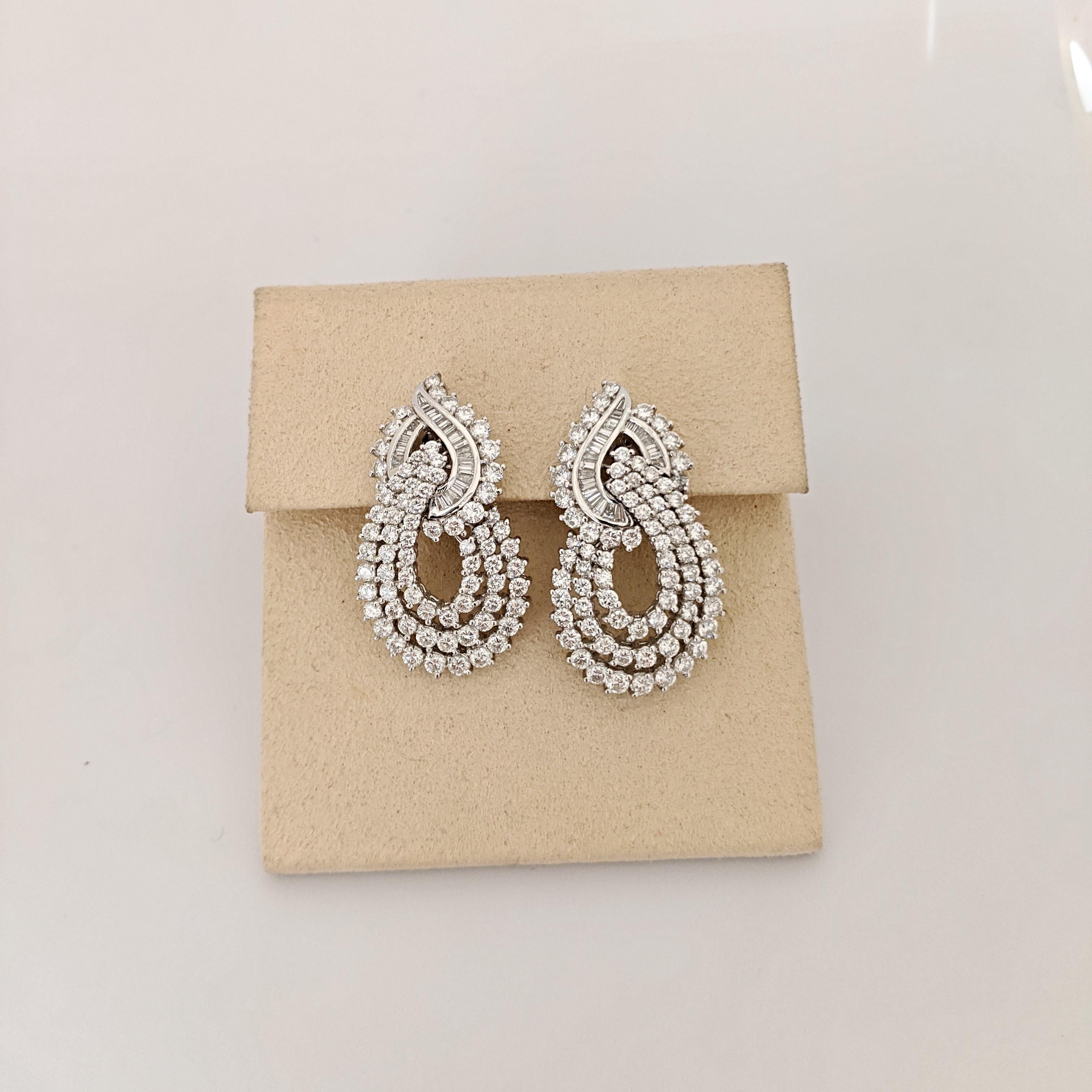 Cellini Jewelers Elegant Diamond earrings. These Platinum earrings are designed with round brilliant and baguette cut Diamonds. They are in the door knocker style and hang gracefully from the ears. They have a flexible post back making them suitable