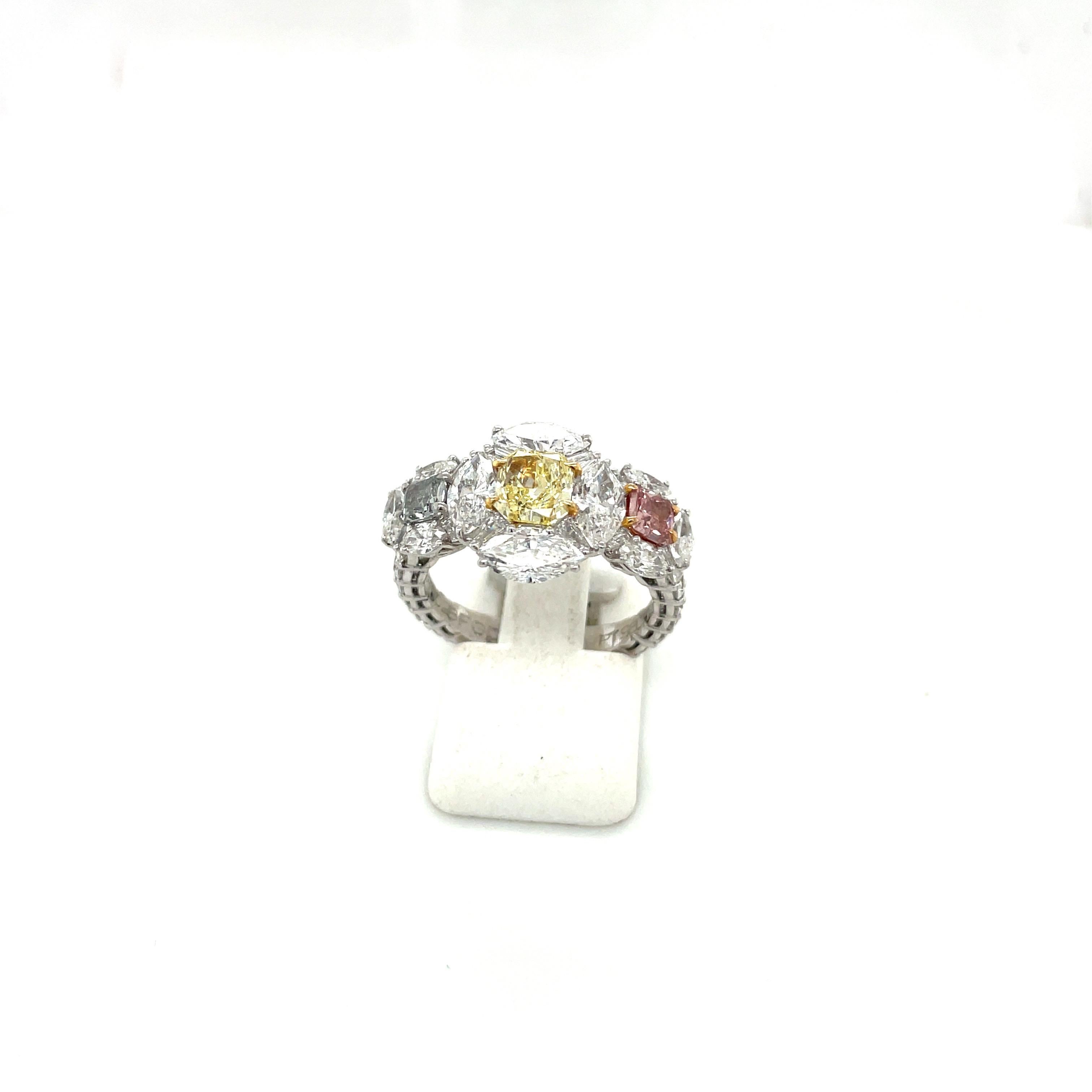 Classic and elegant is the best way to describe this 3 stone fancy colored diamond ring. The 3 radiant  cut pink, yellow and grey blue diamonds are set in a platinum setting. Each center stone is surrounded by white marquise and baguette cut