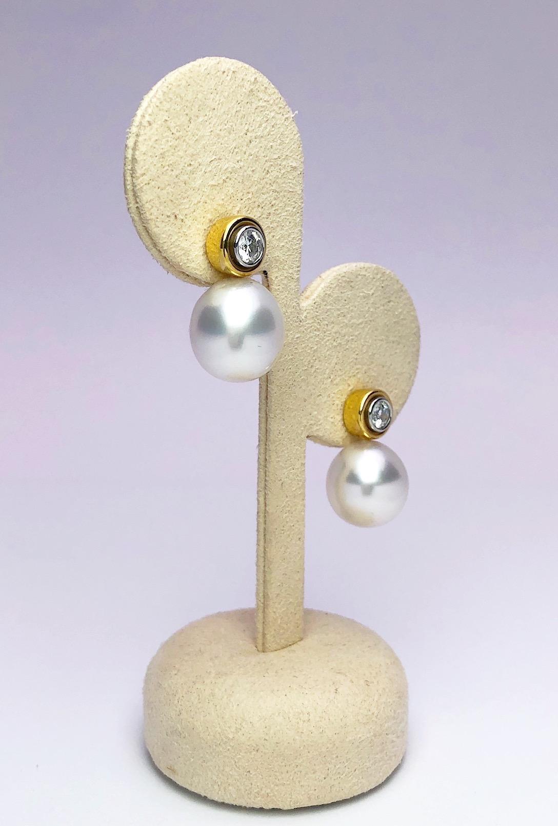 Classic South Sea Pearl and Diamond earring by Cellini Jewelers NYC. The earrings are designed with round brilliant diamonds set in an inner platinum bezel, then set in a larger 18 karat yellow gold bezel. A South Sea Pearl hangs from the bezel .The