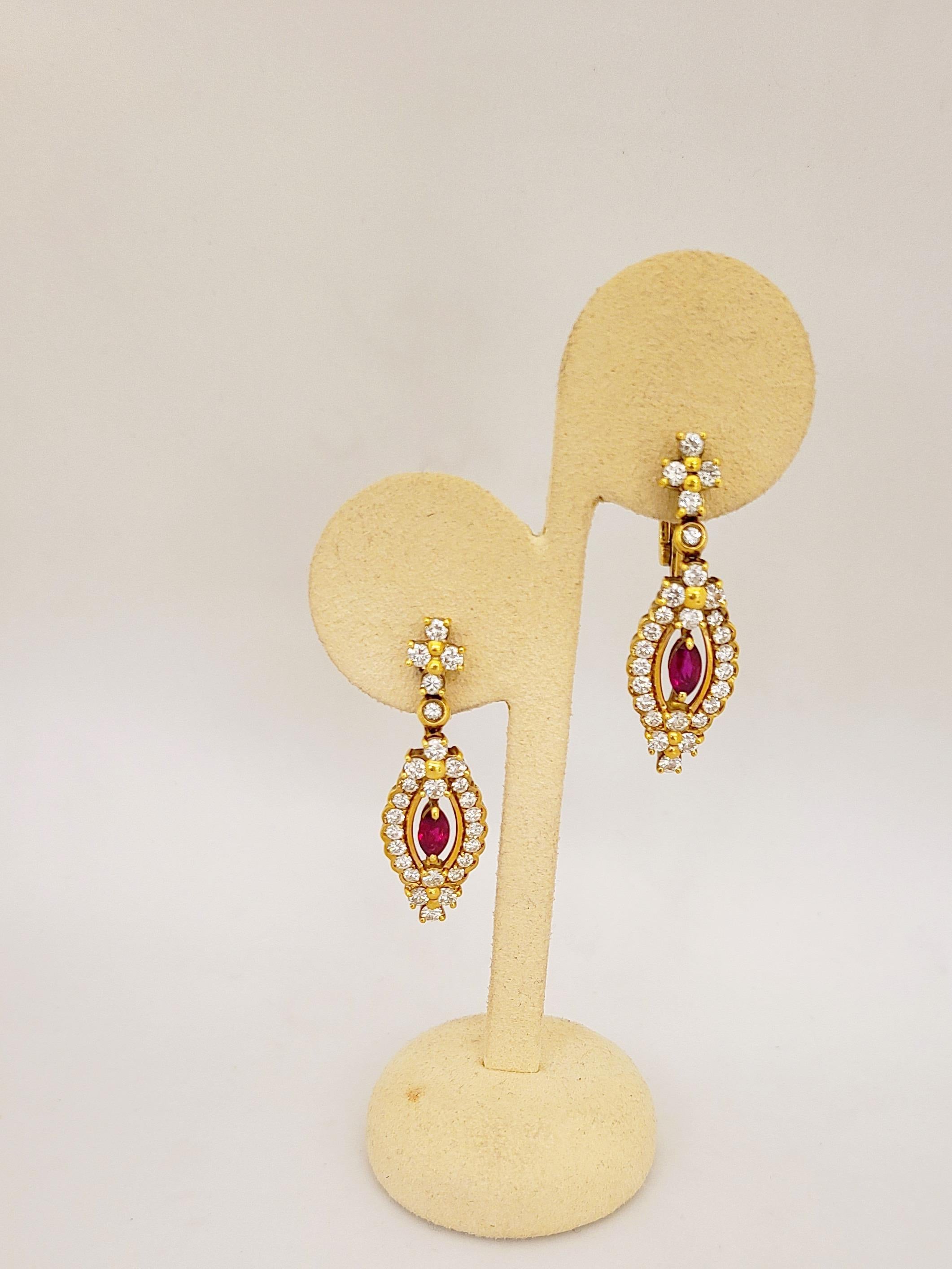 18 karat yellow gold earrings, by Cellini Jewelers NYC featuring marquise shaped ruby centers surrounded by round brilliant diamonds. The 1.5
