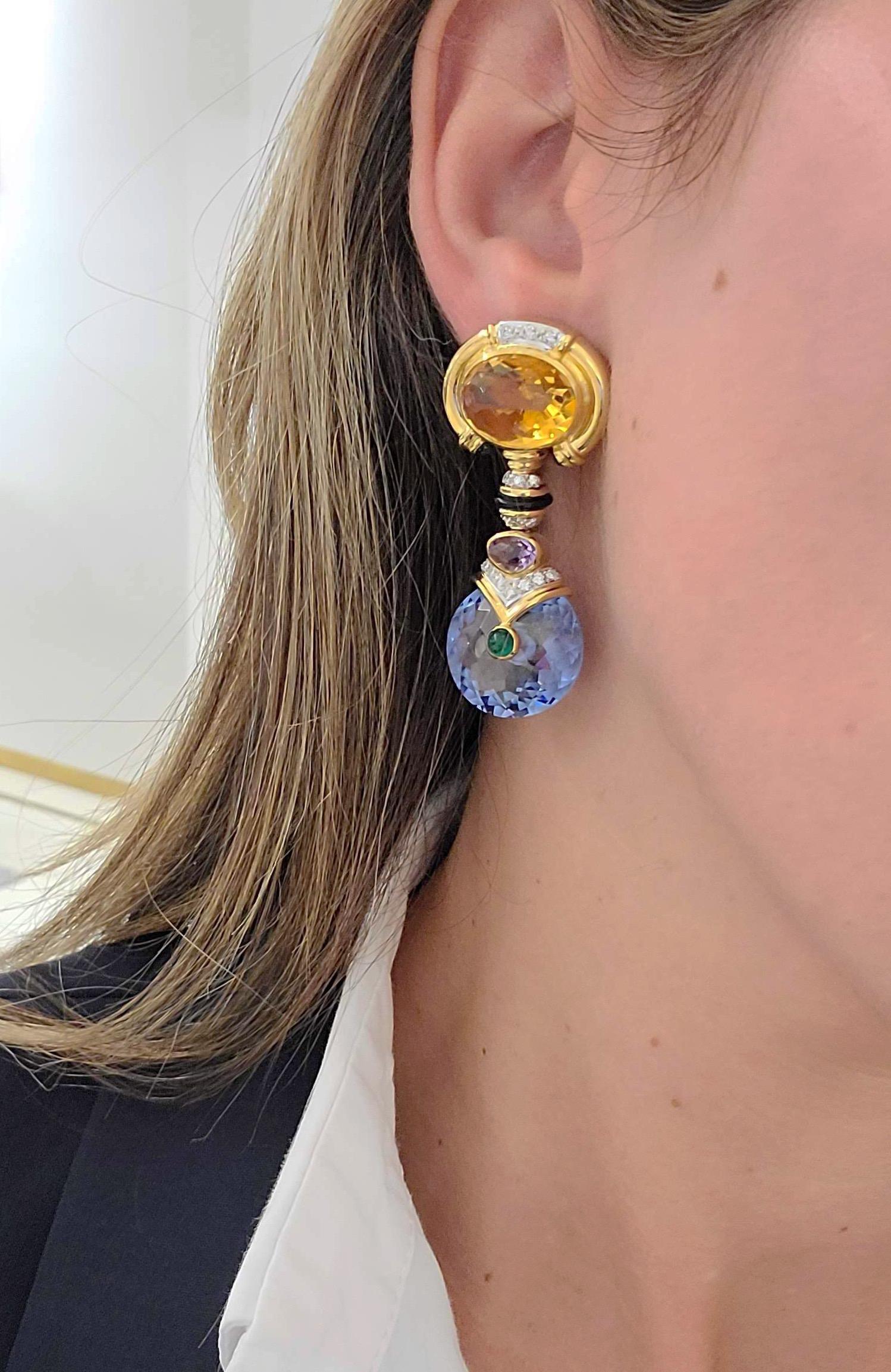 These amazing 18 karat yellow gold earrings were designed for Cellini in 1993. The tops of the earrings are set with a large oval citrine, which has been accented with diamonds and emerald cabochons. The drop part of the earrings are set with bezel