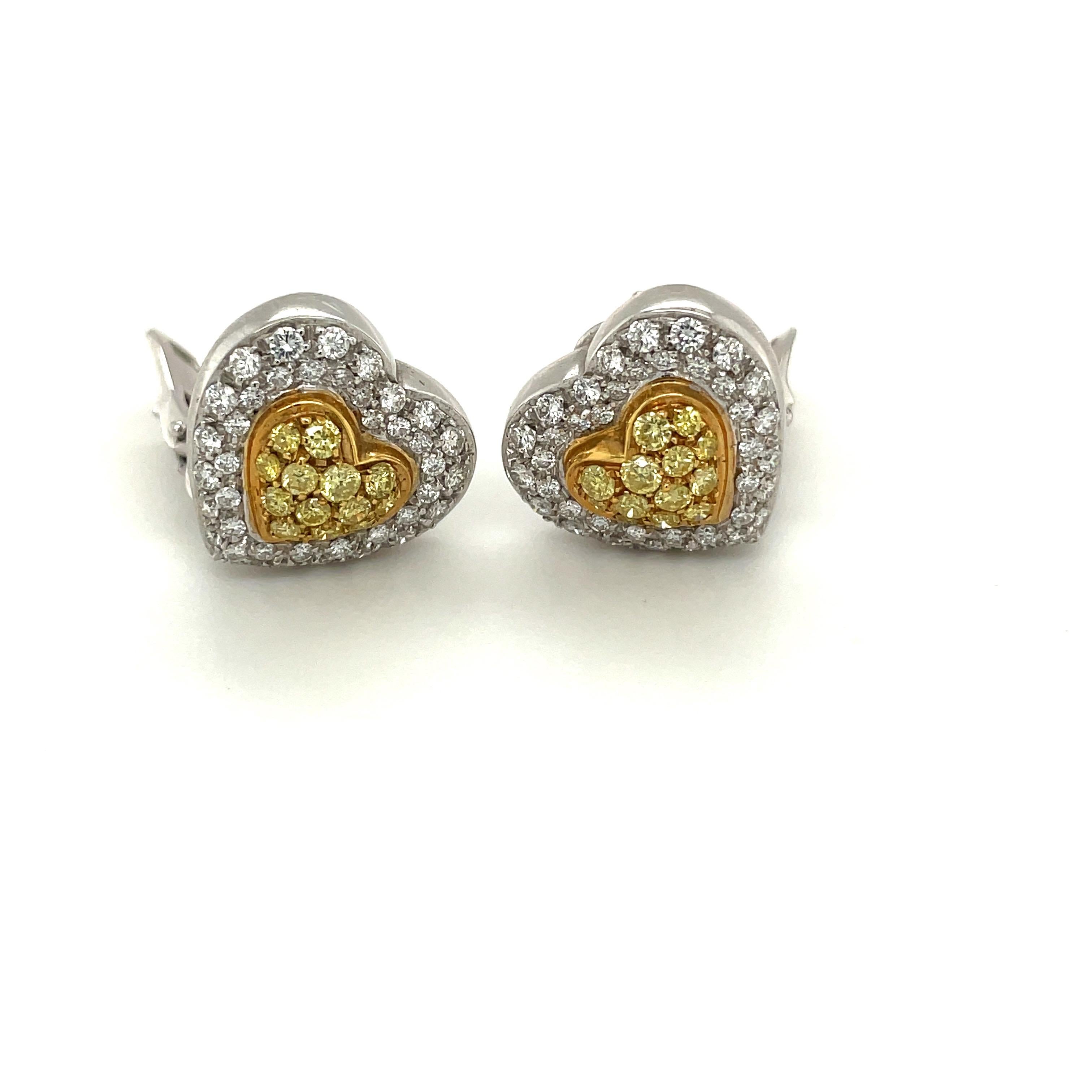 Sure to make your heart flutter, these charming heart earring are set in 18K yellow and white gold. Featuring 0.95cts of brilliant white diamonds, and 0.64cts of exquisite yellow diamonds. The earrings measure approximately 5/8