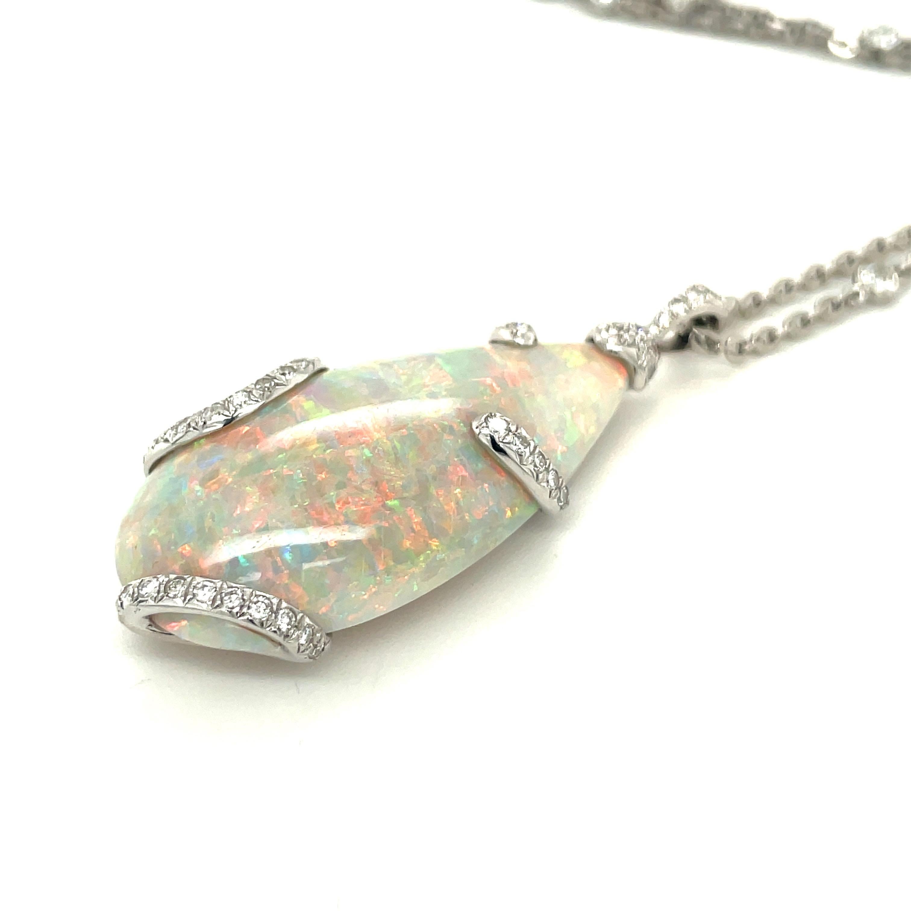 This awe inspiring pear shaped 38.81 carat fine opal is set in platinum with 0.66cts of white diamonds accenting the fire in this gem. Hanging off a 30