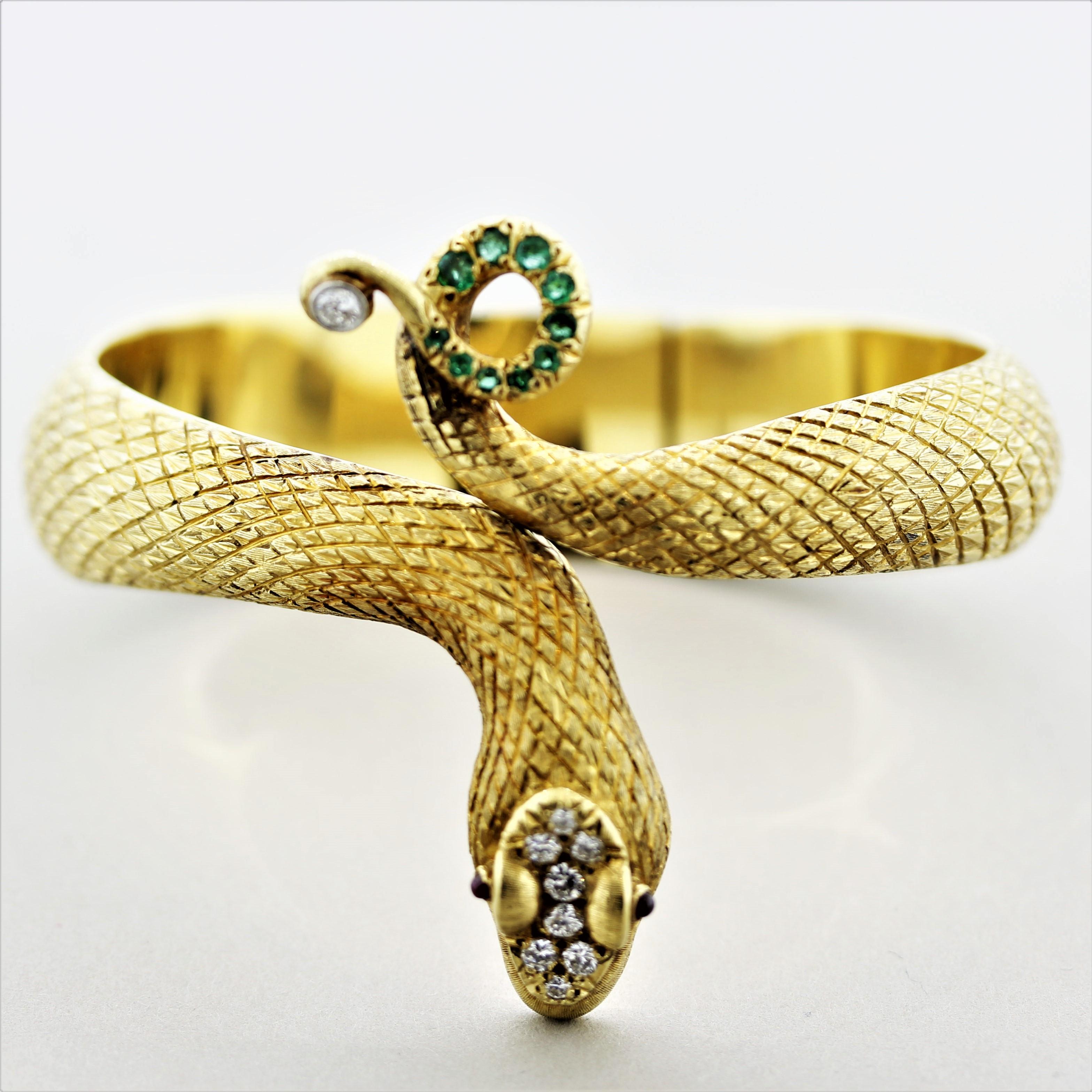A superb estate bangle snake set with diamonds and fine colored stones. The snake is made in 18k yellow gold with life-like features that sets this piece apart from the rest. The outside of the snake has hand-carved and textured scales, while its