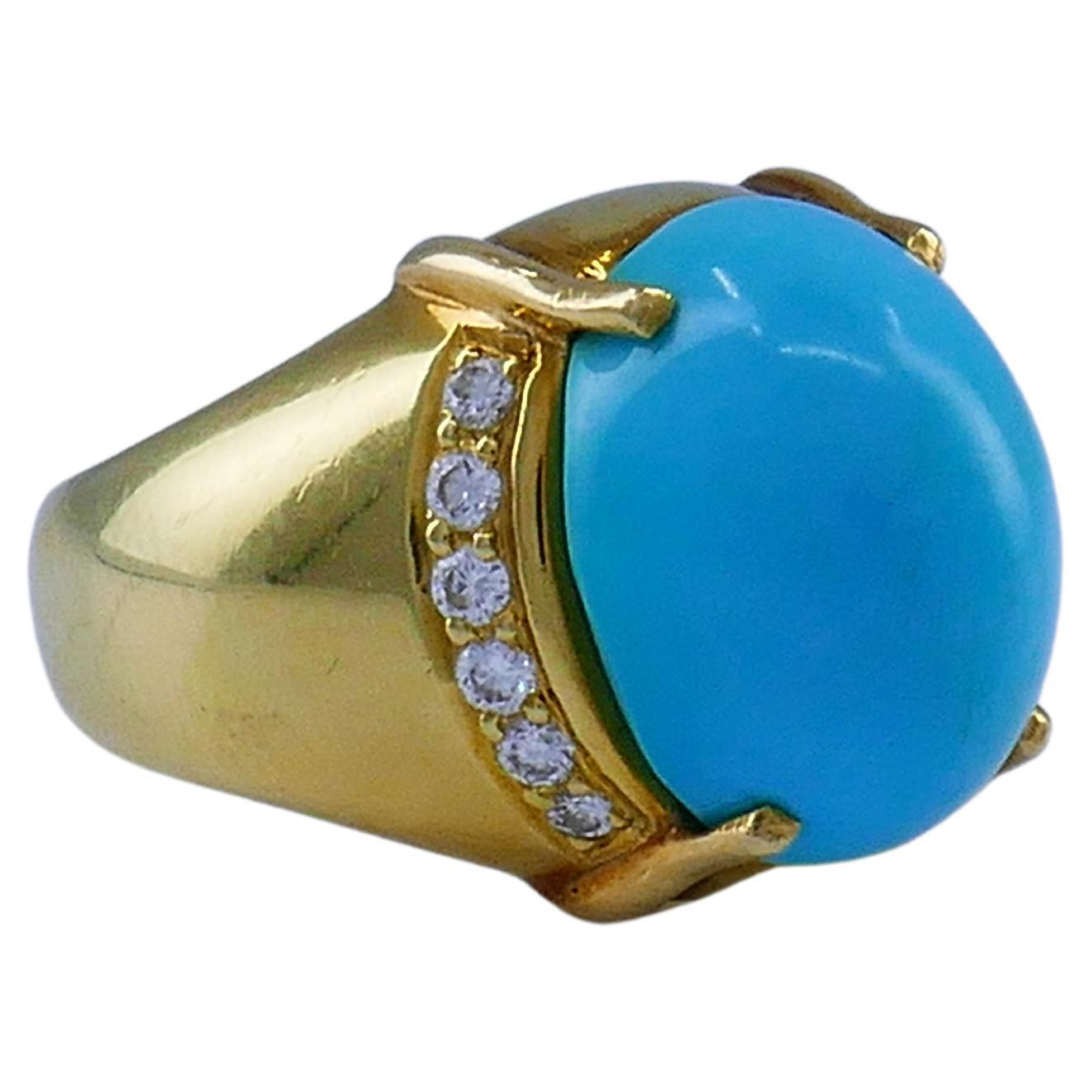 A beautiful 18k gold ring by Cellino, features turquoise and diamonds.
The turquoise is oval cabochon cut. It’s a beautiful stone, four-prong set. There are twelve diamonds, six on each side of the turquoise. The shank is wide in the front and