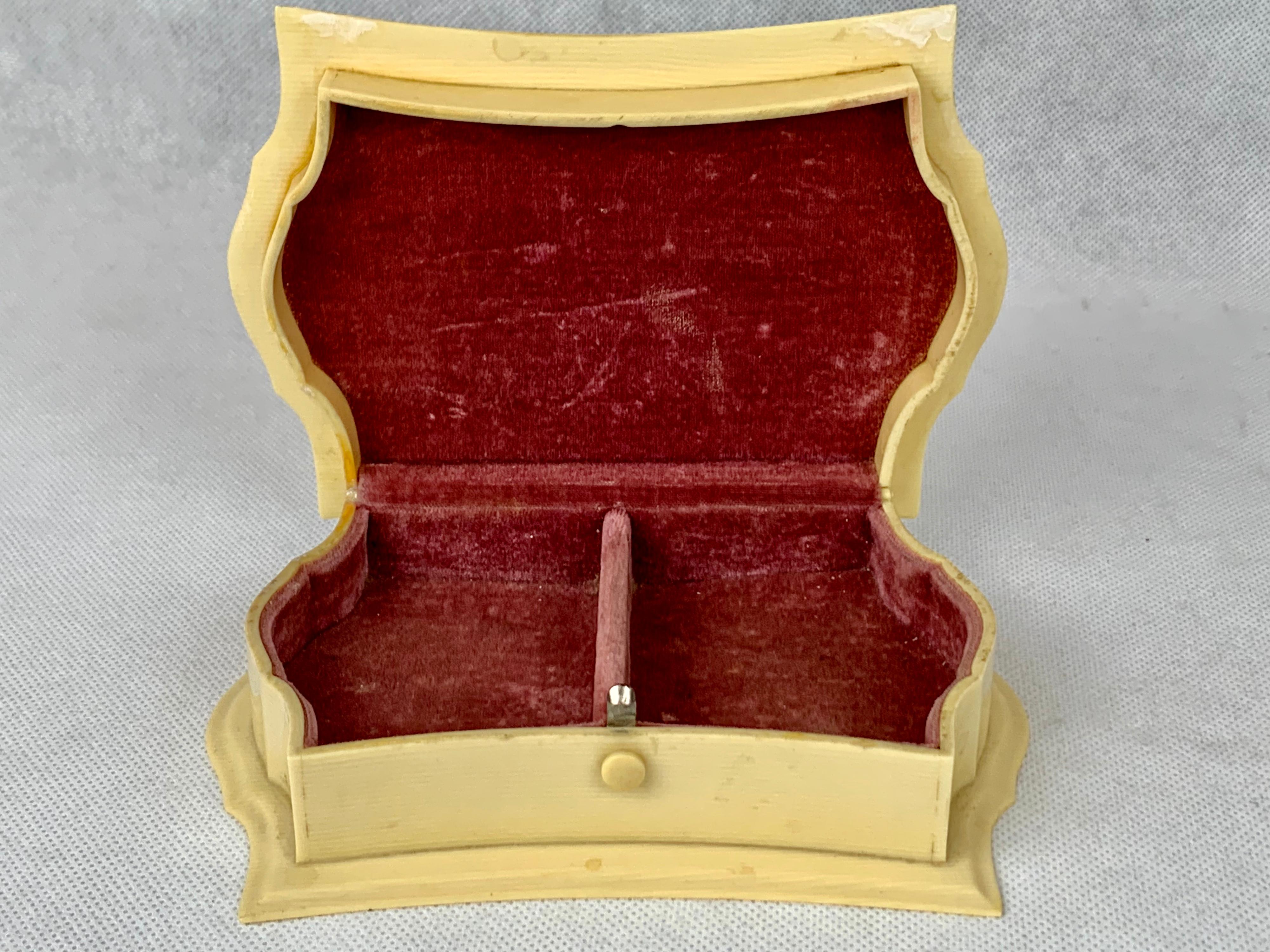 Celluloid made its appearance in the mid-19th century. One of its most popular forms was to imitate ivory including the grain lines. This jewelry box is marked 