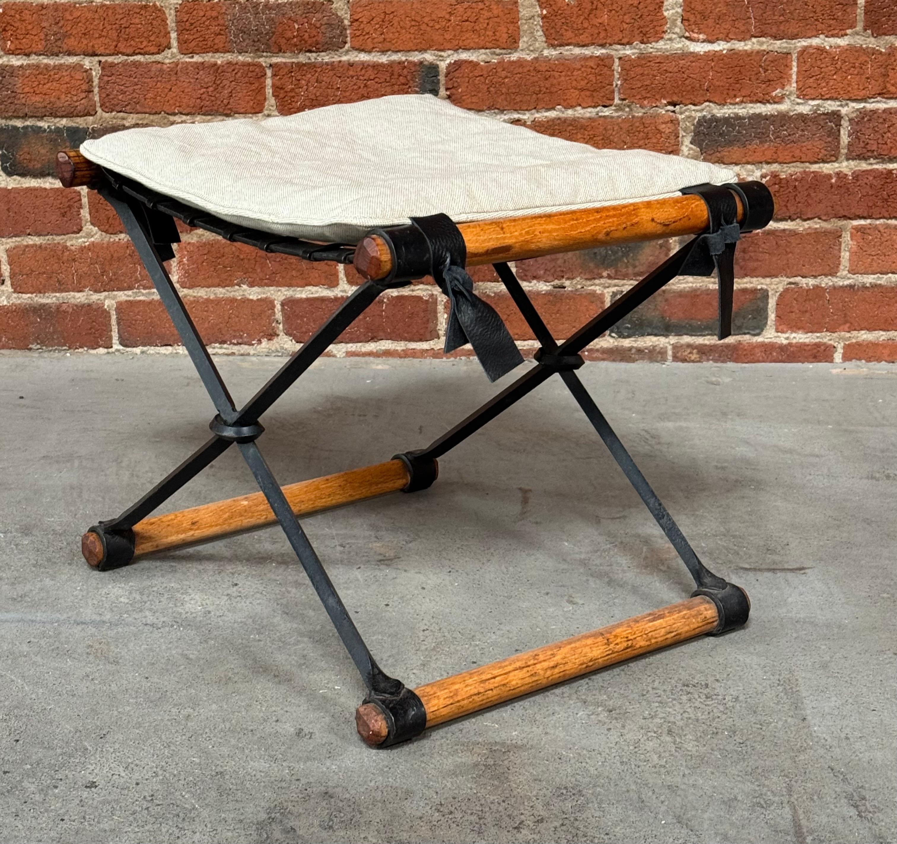 American architect, landscape architect and furniture designer Cleo Baldon (1927-2014) X- base stool with a dark green wrought iron frame with fumed oak runners circa 1960s for her company the Terra Collection. With a new canvas cushion with leather