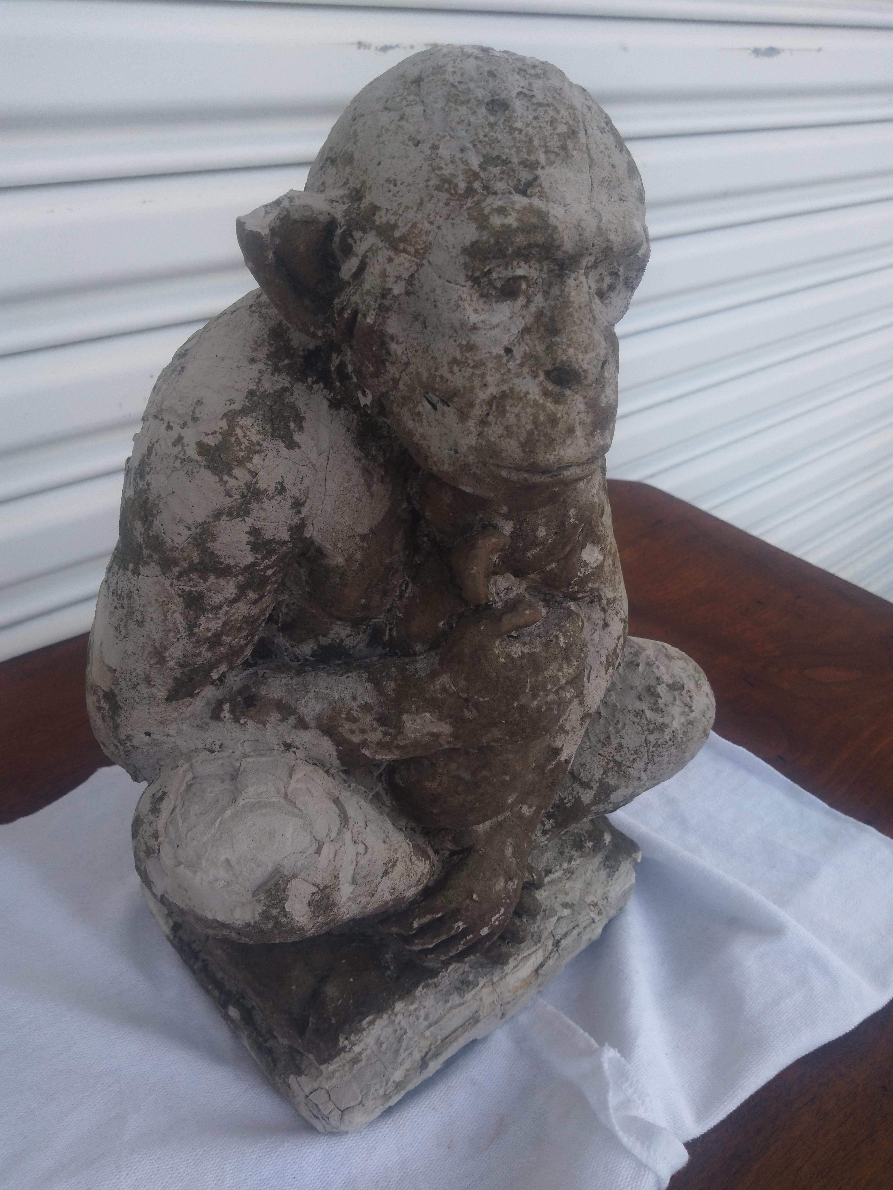 This statue is cast from cement and it depicts a monkey carrying it's infant child. It's patination lends to its age. 