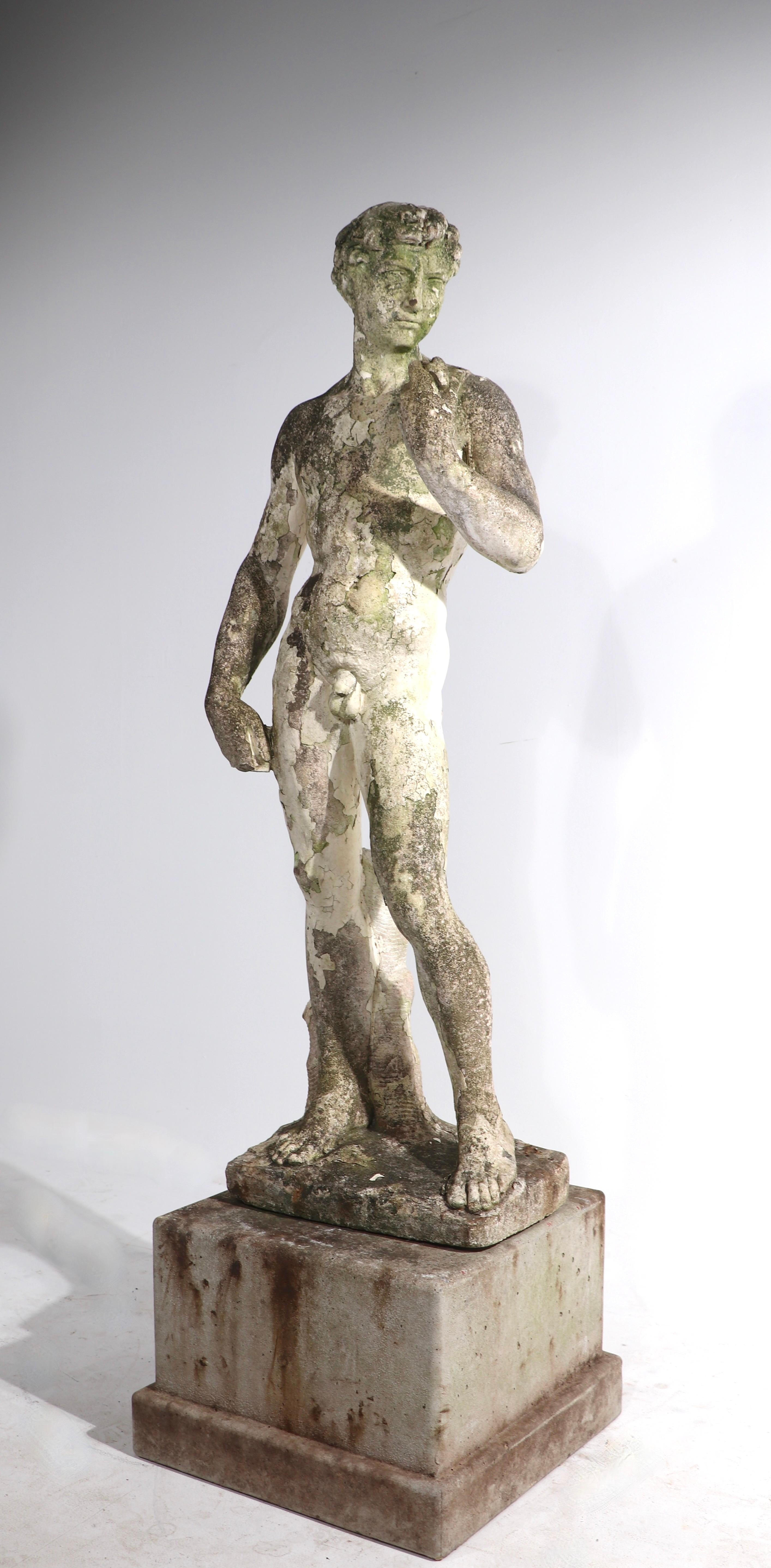 Charming vintage poured stone statue of David, on cement block pedestal. Wonderful aged patina, free of loss, structural damage or repairs. Suitable for indoor or outdoor use, figure H w/o base 45 in. x Total H 56 in. Base 16.5 x 16.5 x 11 in. H.