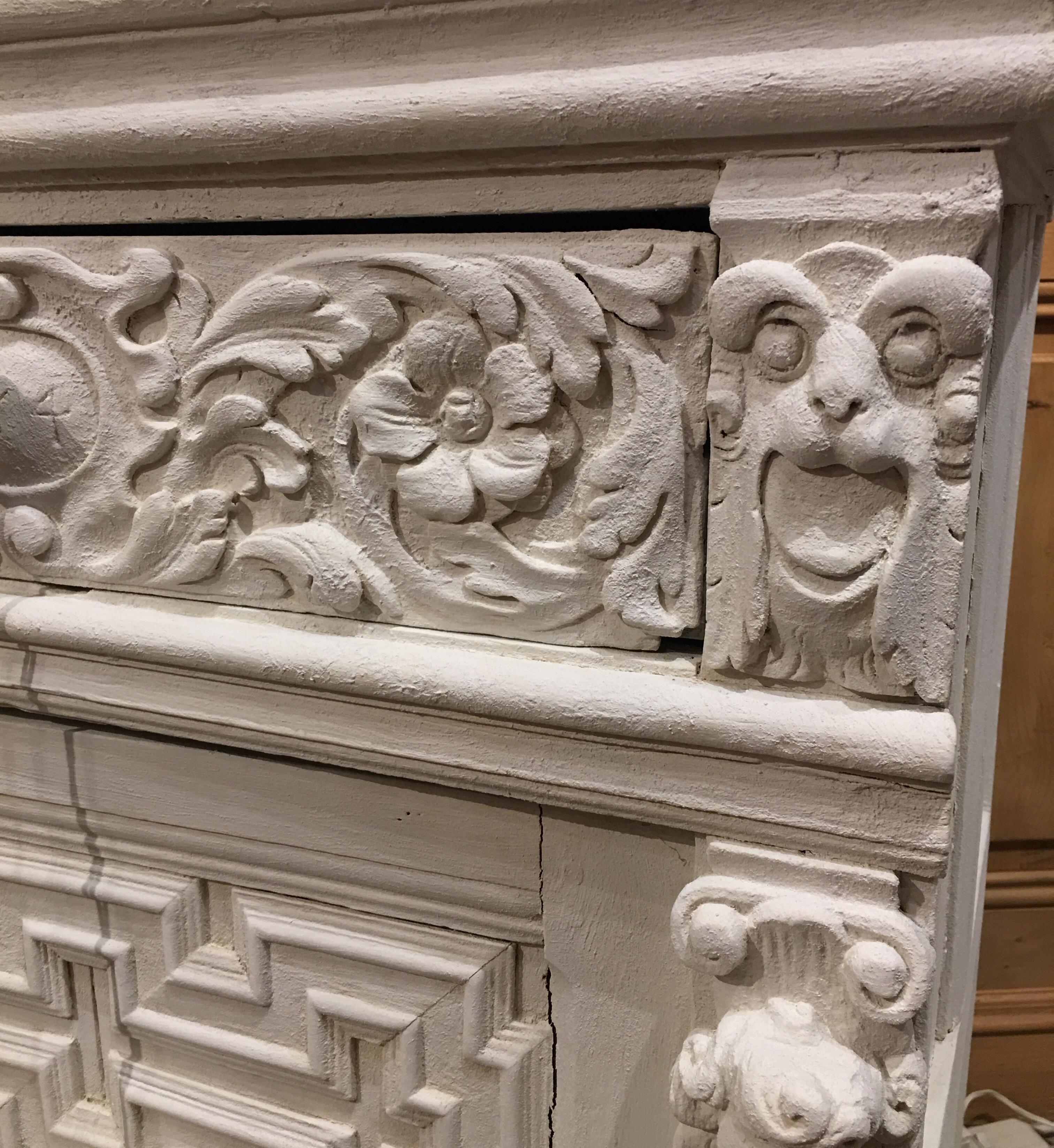 This beautifully carved, early 19th Century cabinet has lovely carvings and has been recently refinished with Joan Westwater's Cement Finish. The stiles and door are graced with cherubs, acanthus carvings and geometrically patterned mouldings. The