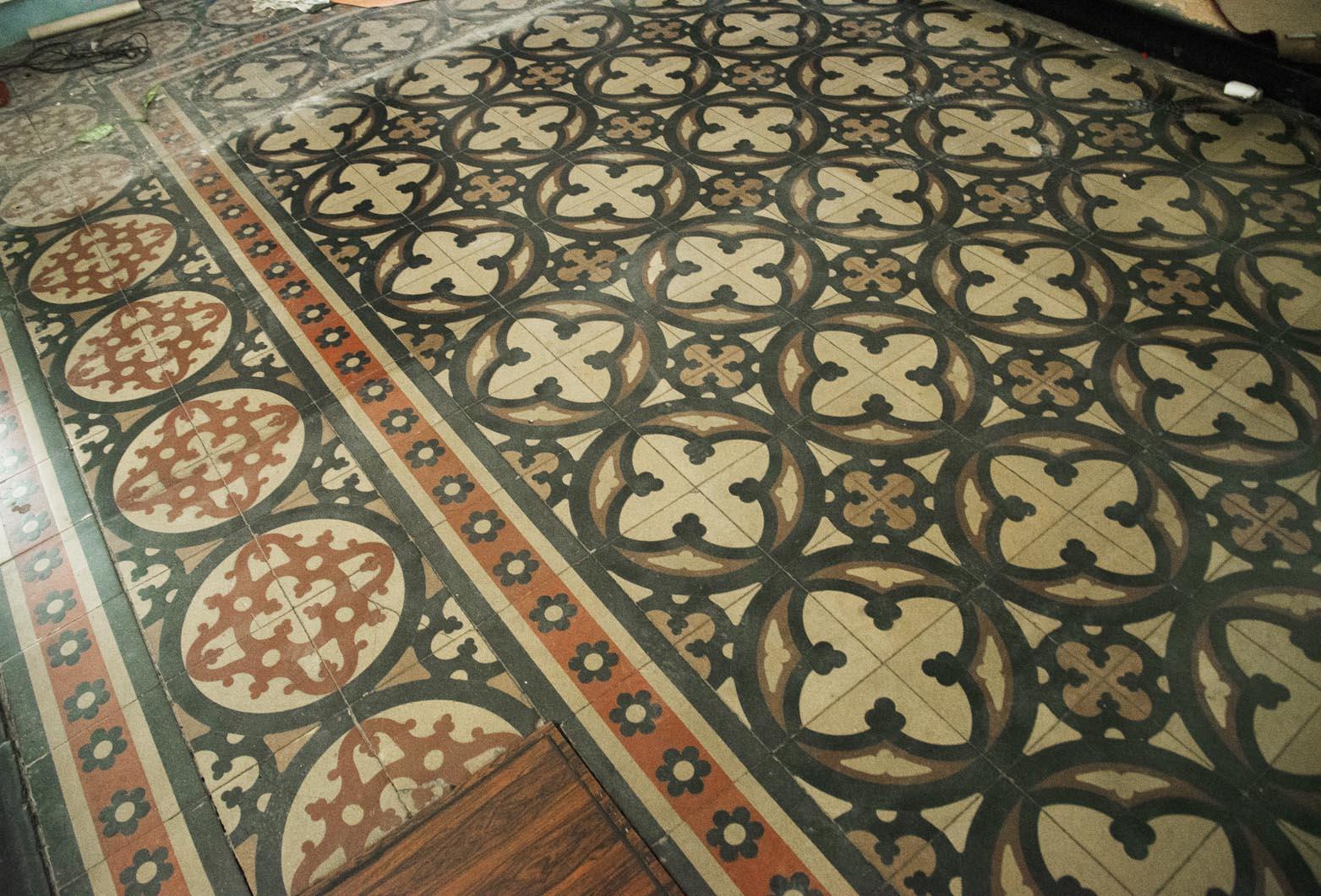 Questo pavimento autentico è composto da piastrelle di cemento riccamente decorate provenienti da una chiesa. La composizione dinamica risalente al XIX secolo è caratterizzata da motivi rossi, neri e bianchi, che formano un insieme importante sia