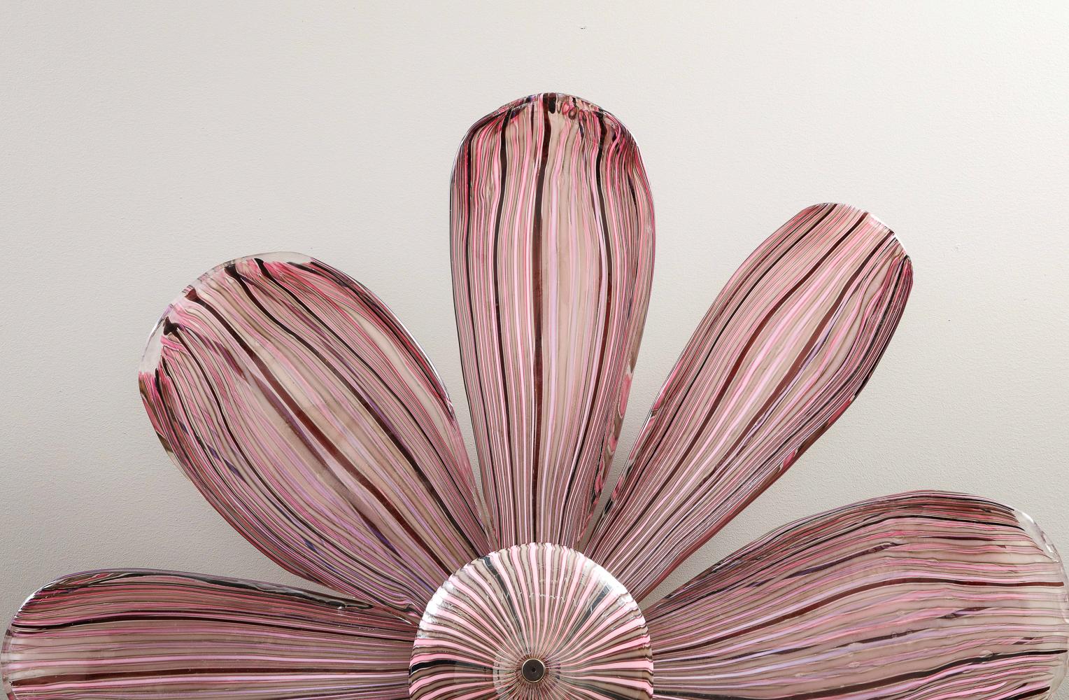 Margherita Illuminated Wall Sculpture by Cenedese.  Blown glass, steel. Massive sculpture of a daisy, custom made by Cenedese, Murano. Freehand glass elements with caned stripes in shades of maroon & pink. Concealed steel structure for mounting and