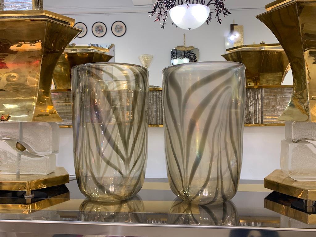 Dreaming of exotic shores? of Safari storytelling? Be inspired by this one-of-a-kind Italian contemporary pair of Art Deco design Murano glass vases, entirely handcrafted. The blown body in a unique sophisticated smoked amber transparent color