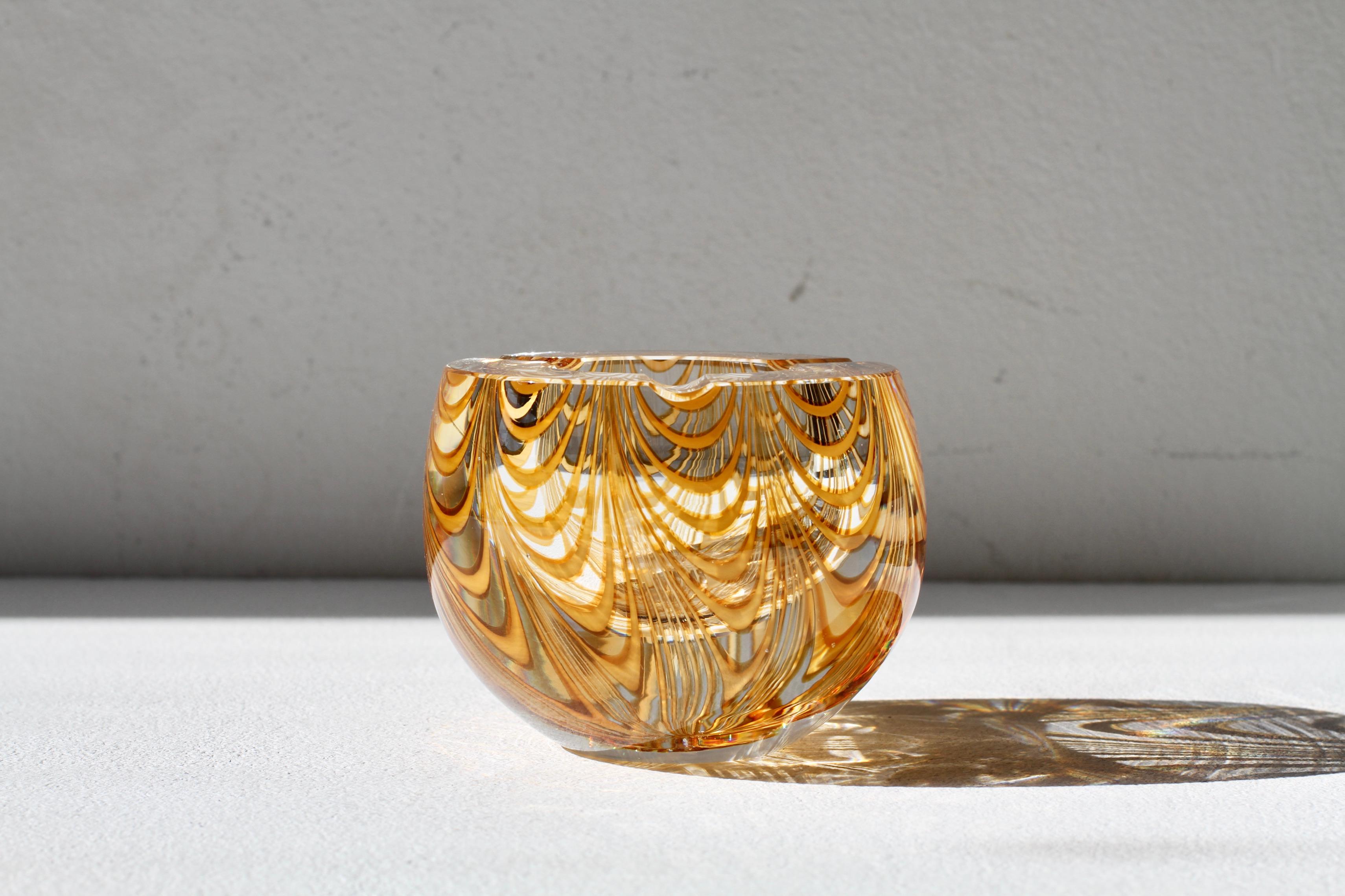 Antonio da Ros (attributed) for Cenedese thick and heavy vintage Mid-Century Modern Italian Murano glass ashtray, circa 1965-1975. This heavy piece of glass features an asymmetric design of amber toned glass curved 'Zebrato' stripes encased in clear