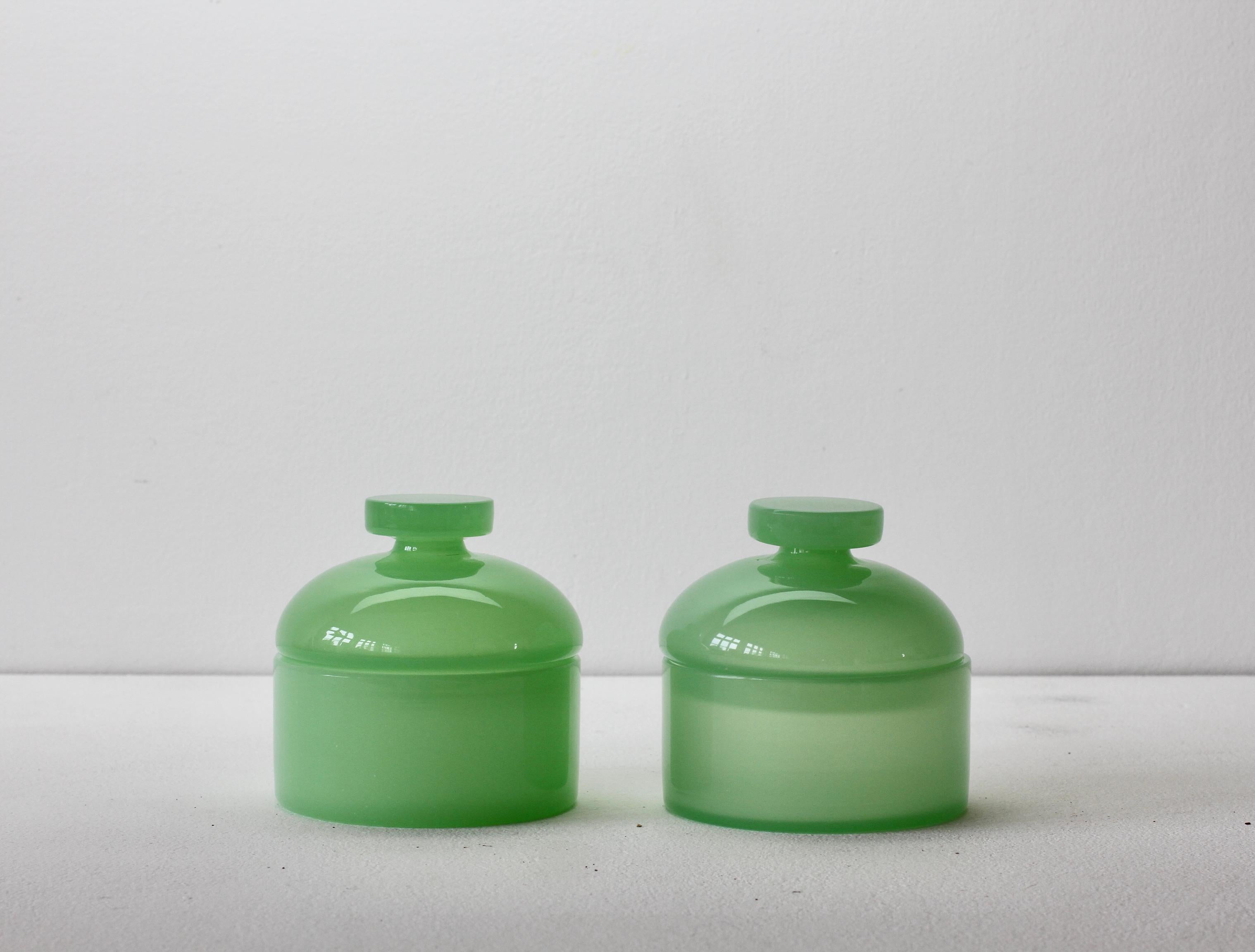 Cenedese vintage midcentury pair of new old stock Murano opaline green colored / coloured glass round Apothecary jars or storage containers with lids made circa 1970 with original paper labels attached. Wonderful Italian glass and perfect for