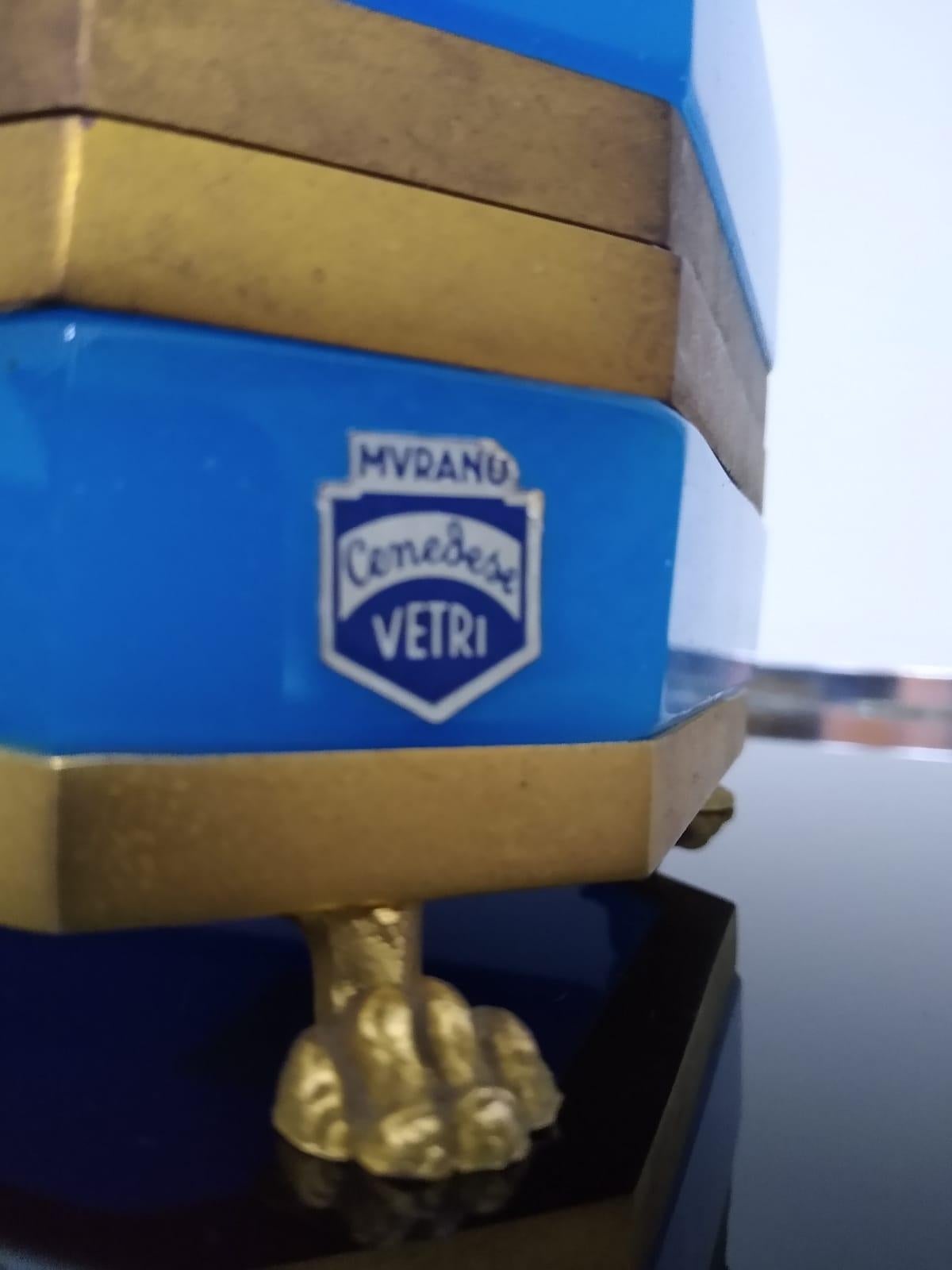 Boîte à bijoux de Murano par Giovanni Cenedese.
Le Label est encore sur la boîte : Murano Cenedese Vetri.
Cette boîte à bijoux absolument magnifique présente du verre bleu de Murano, des bandes de métal doré sur la base, ainsi que deux bandes sur le