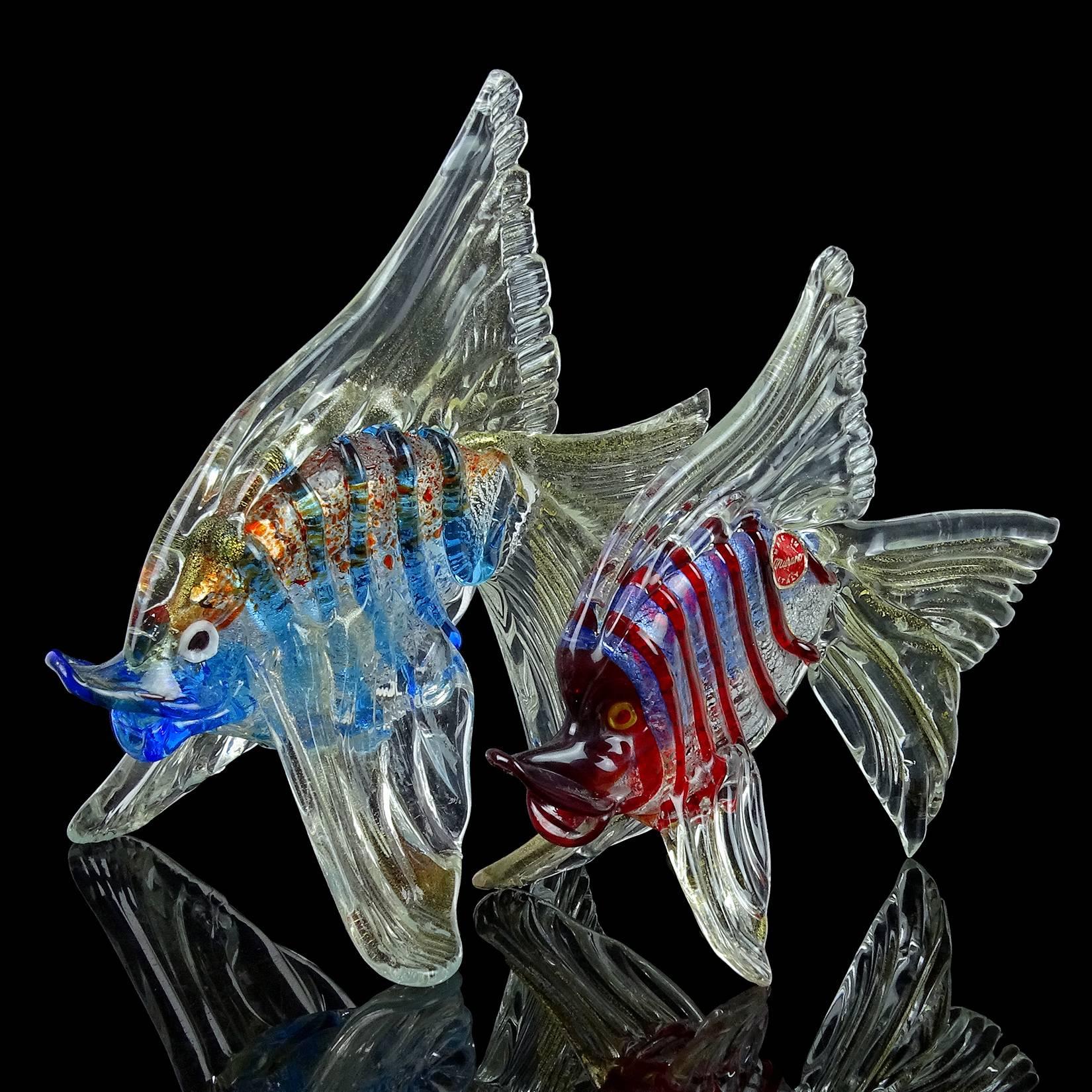 Beautiful pair of Murano hand blown freestanding blue / orange and red / blue Italian art glass fish sculptures, with silver and gold flecks. Documented to the Cenedese company. Each has a striped body, with dots of pigment on the top part of the