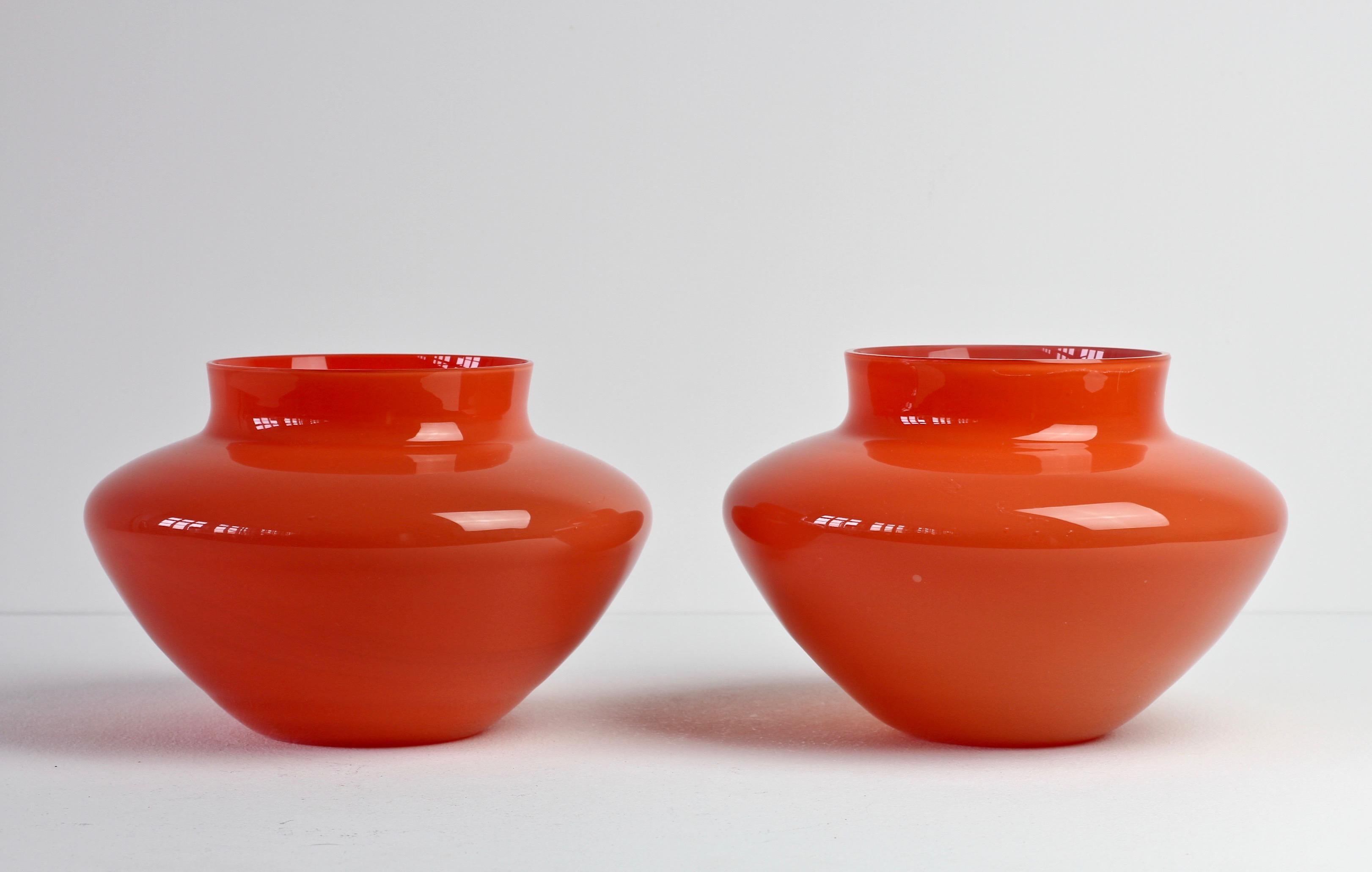 Cenedese Vetri of Murano, Italy. Particularly striking are the vessel's elegant form and bold, red color. One vase seems to have been made in the latter half of the Mid-Century in circa 1967 and has the old style Cenedese label on the base - the