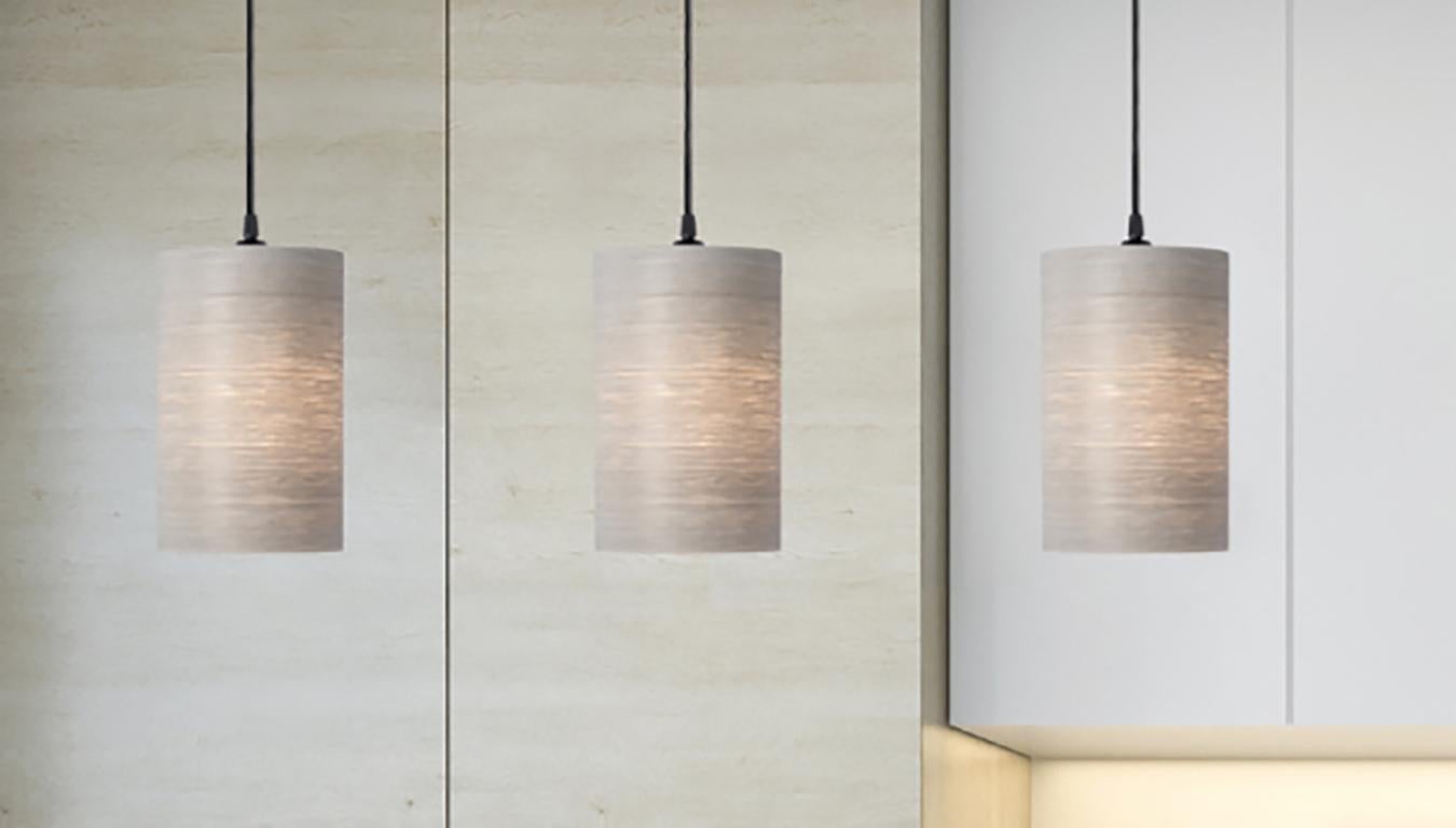 CENTA is a contemporary, Mid-Century Modern light fixture. This is a minimalist luxury pendant design and can be exhibited in dining rooms, entryways, alcoves, and over kitchen islands. Gray Tay is harvested from the African Koto tree. The
