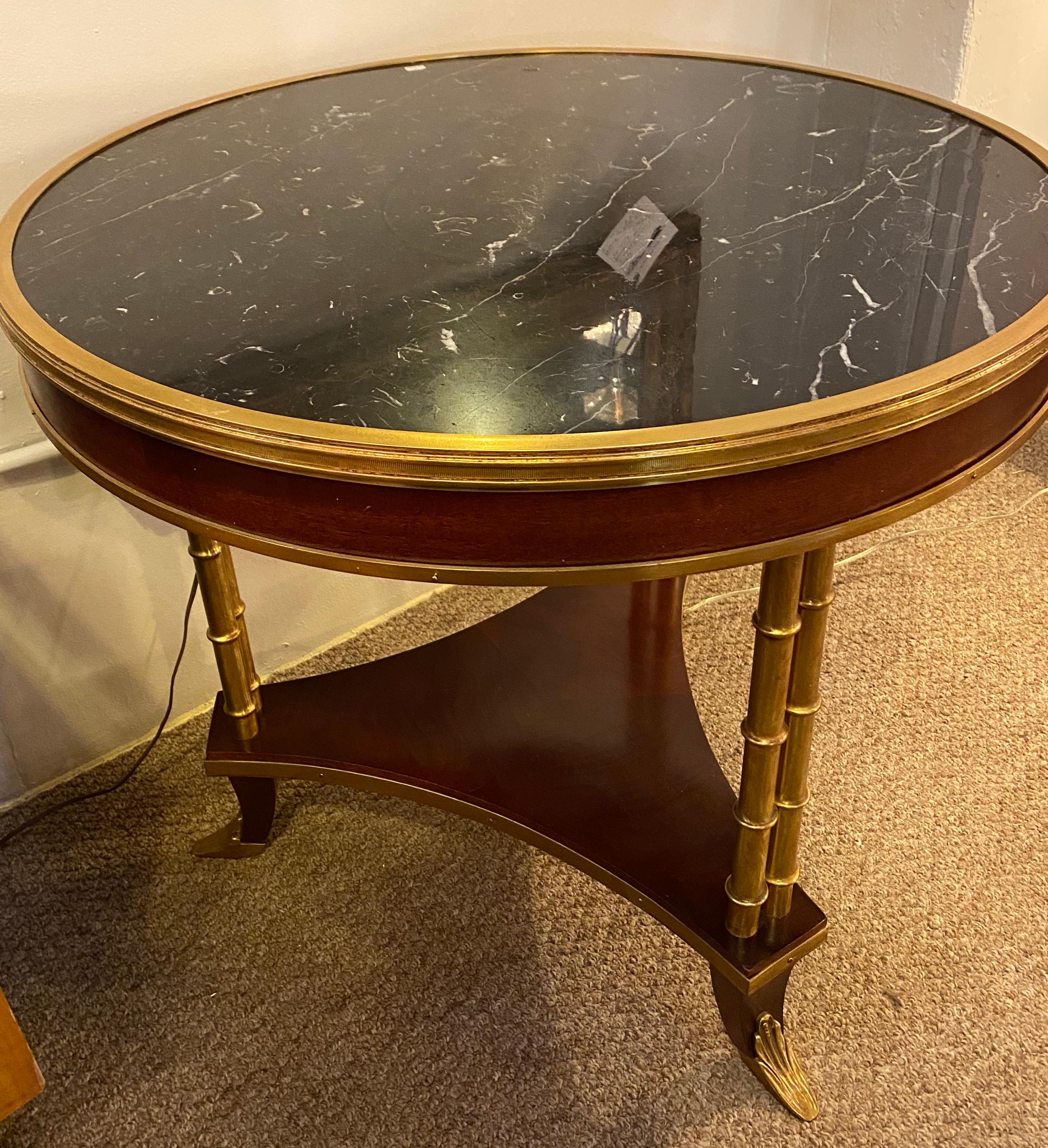 Mahogany Hollywood Regency bamboo form Bouilliote, end or center table in the style of Maison Jansen. This spectacular center or end table is stunning having a bronze framed Black and white veined marble top with a bronze framed apron supported by