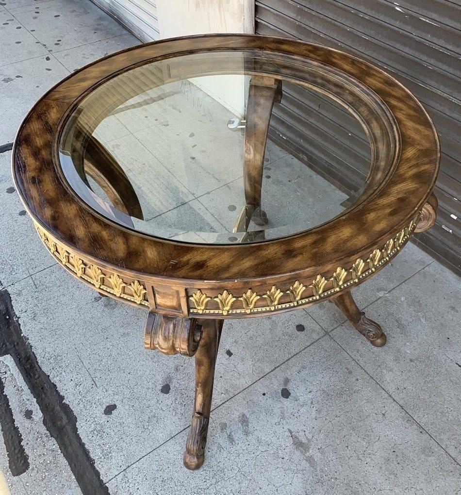 Beautiful center or entry table designed and manufactured in the Philippines by La Barge.
The table has beautiful carved frame and solid brass accents with a glass top that allows to appreciate the brass details on the bottom stretched.

The