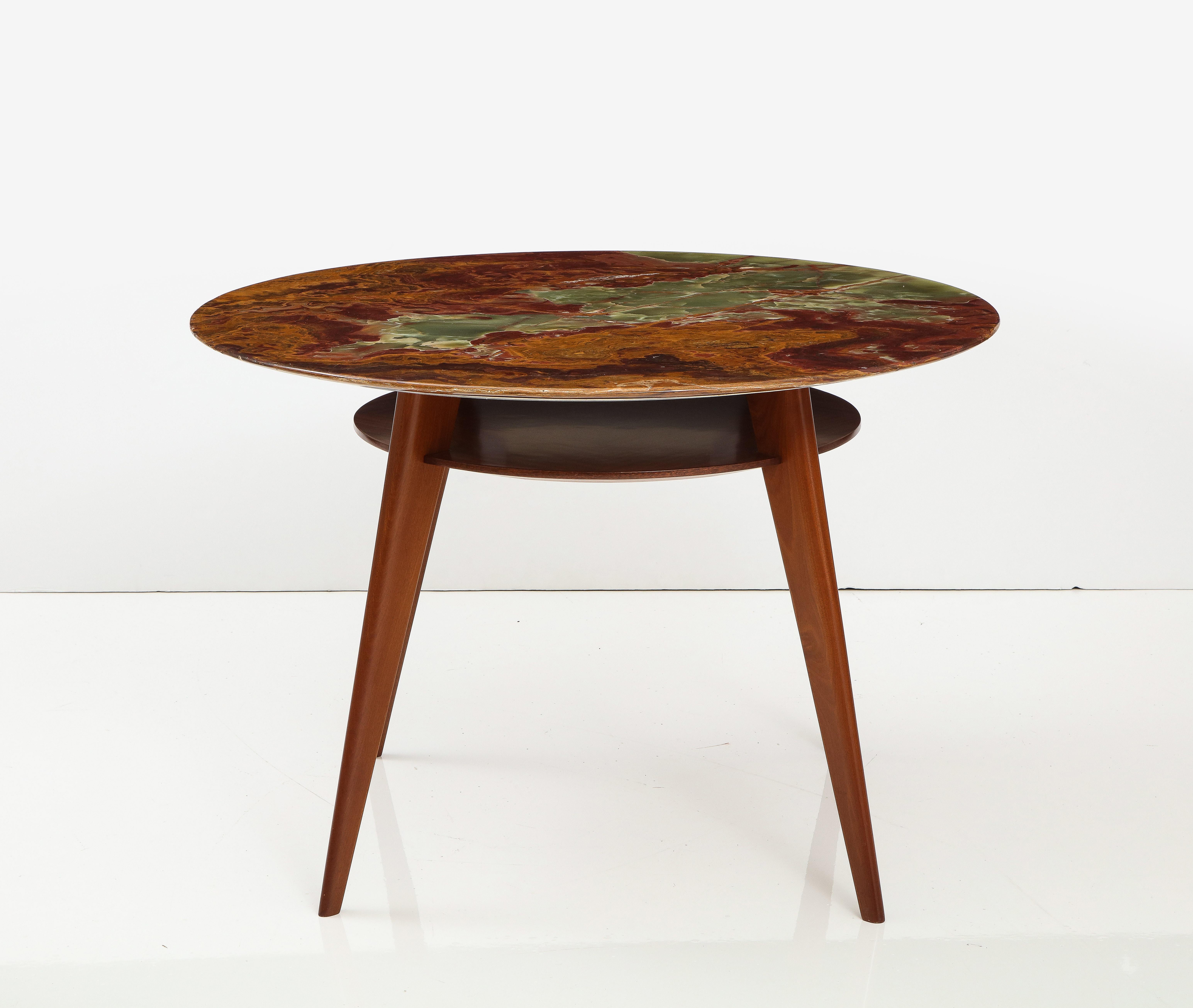 Mahogany and Onyx Center Table, Italy, circa 1950

Vibrant, smooth onyx tabletop with a mid-century Italian base; circular shelf beneath the tabletop, with brass supports running between two of the four tapered legs.

