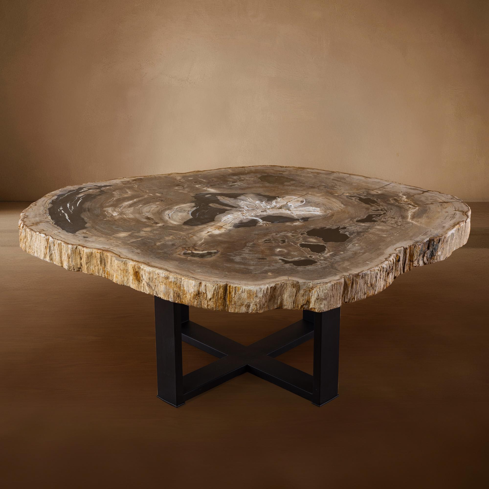 Cette table centrale exquise est un véritable chef-d'œuvre, originaire d'Indonésie, avec une dalle de bois datant de 20 millions d'années, à l'ère du Miocène. La dalle présente son bord naturel d'origine, ce qui ajoute une touche unique et organique