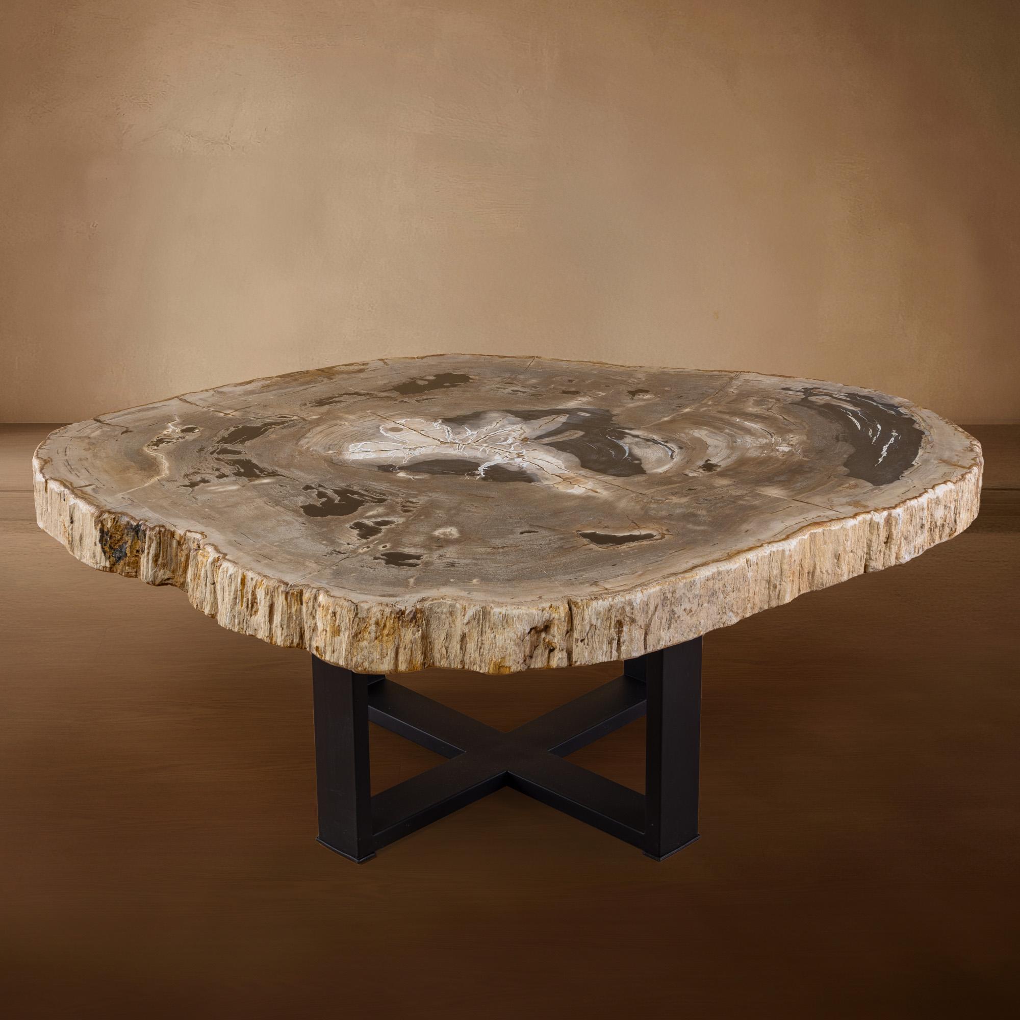 This exquisite center table is a true masterpiece, originating from Indonesia, with a slab of wood that dates back 20 million years to the Miocene era. The slab features its original natural edge, adding a unique and organic touch to its design.