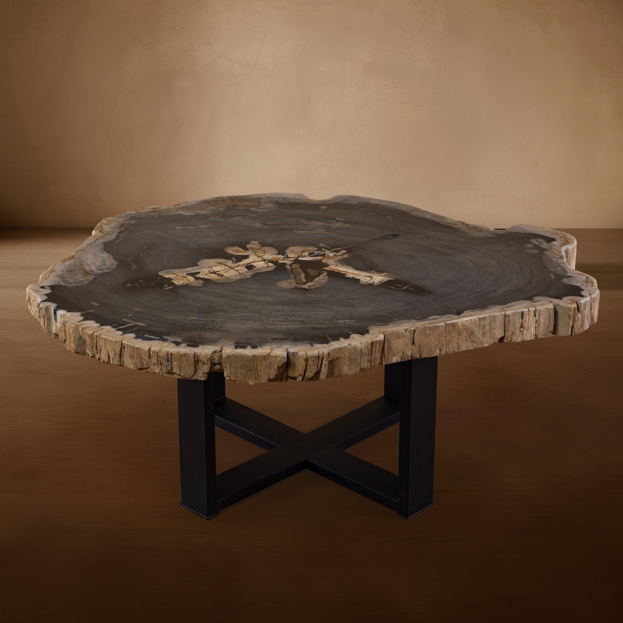 Cette table centrale exquise est un véritable chef-d'œuvre, originaire d'Indonésie, avec une plaque de bois datant de 20 millions d'années, à l'ère du Miocène. La dalle présente son bord naturel d'origine, ce qui ajoute une touche unique et