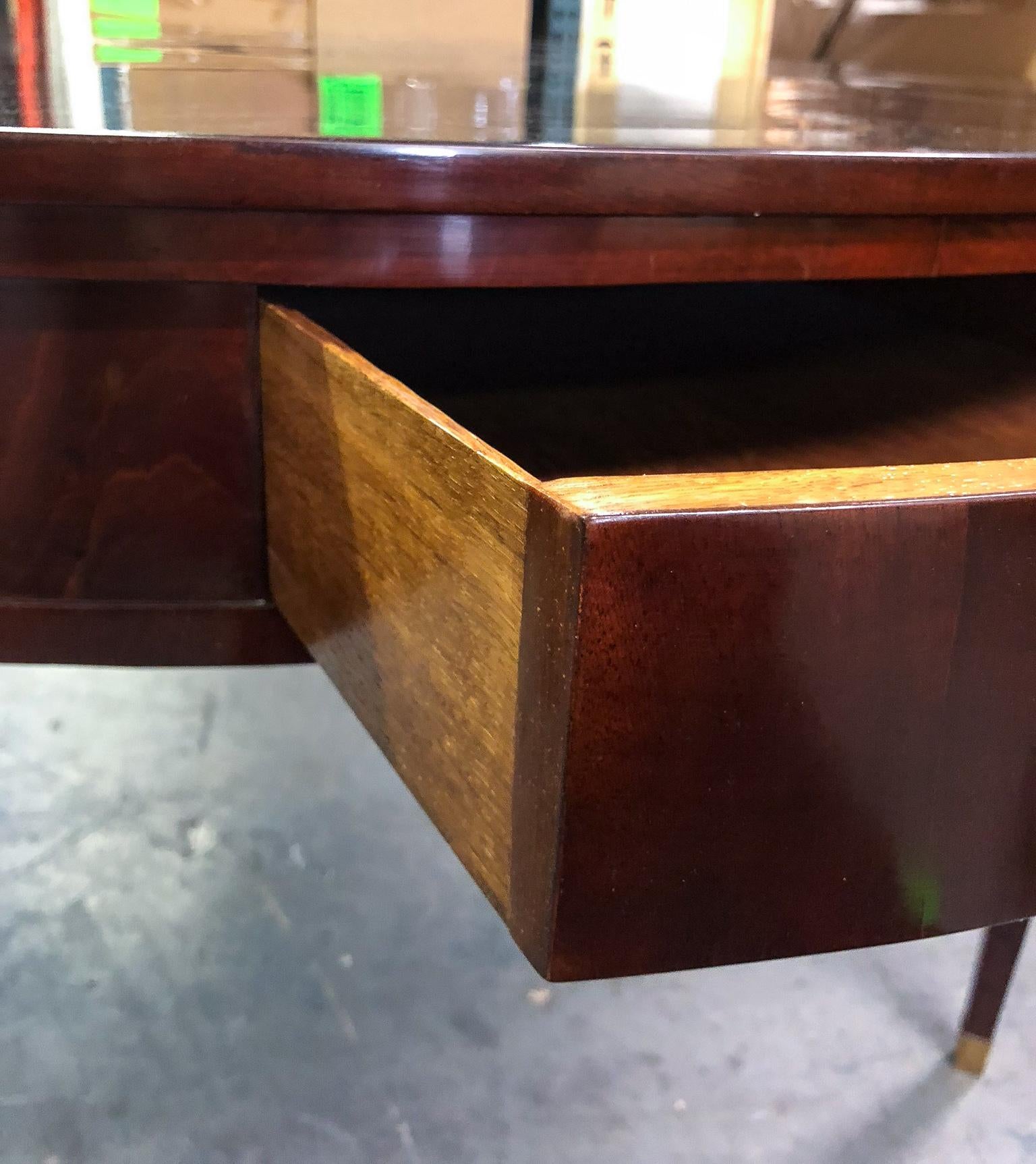 Mahogany veneer on an oak carcass. Four drawers in the apron with brass pulls opening to an oak interior. Raised on four square tapered legs with brass sabots.

OUR REFERENCE N3691