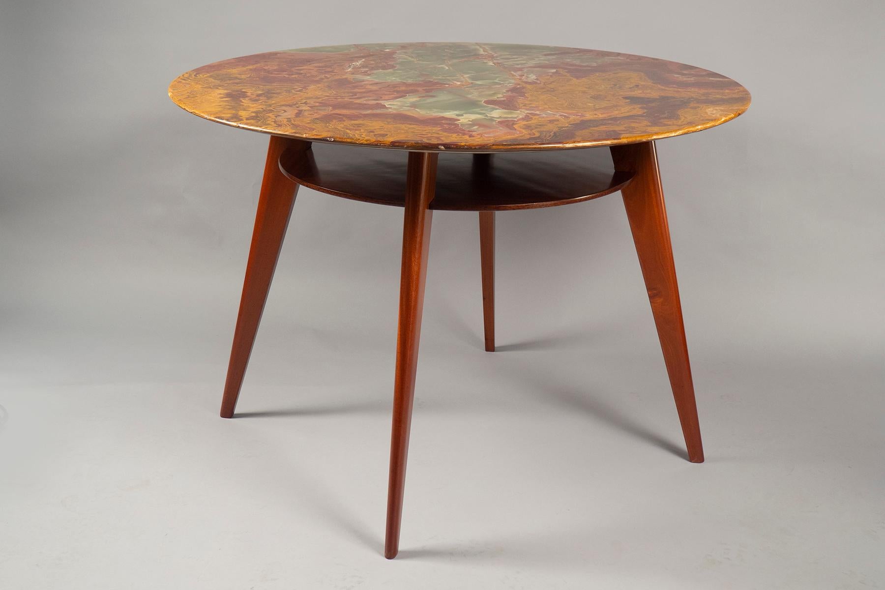 A semi-gloss finished mahogany base with four tapered legs and a round under-the-top shelf (with two brass stretchers), supporting a jade and red/brown mottled Onyx top.