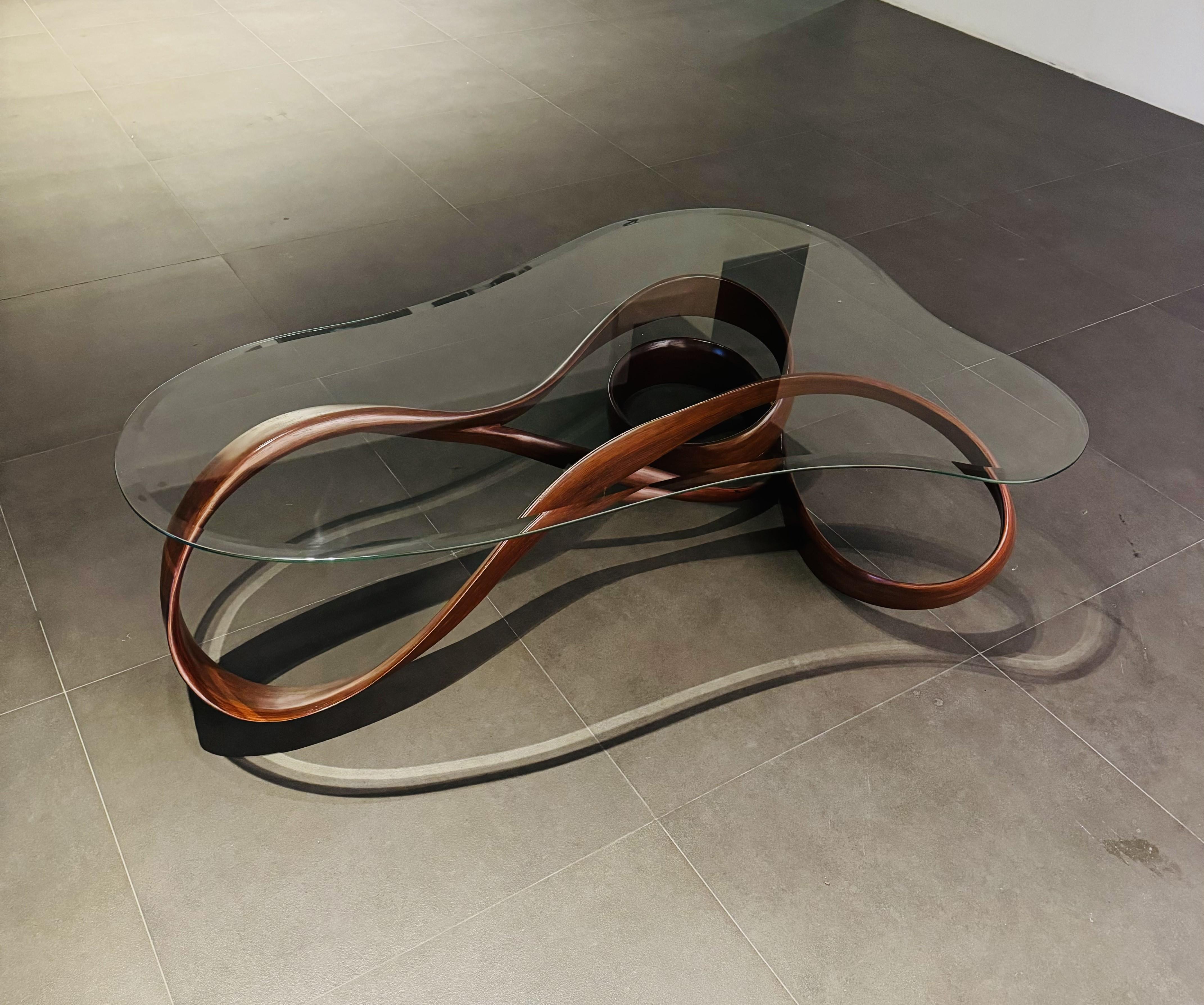 This table is the Center Table No. 1 of the Fluentum Series of works. 

The piece embodies a sculptural base that has been designed with a clean form to focus on the flow of the wood - the wood has been carved to shrink and grow in thickness as the