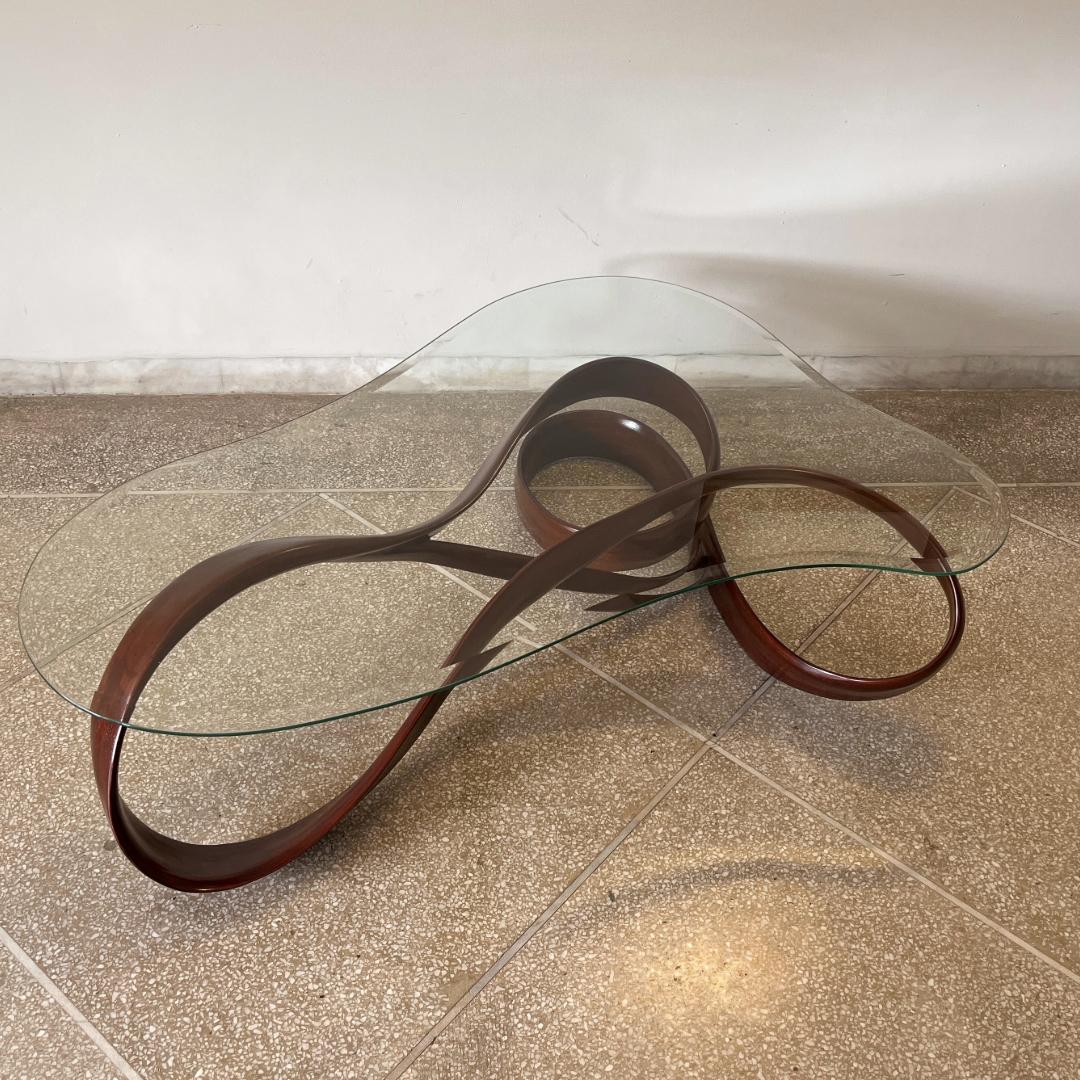 Esta mesa es la Mesa Central nº 1 de la serie de obras Fluentum. 

La pieza incorpora una base escultórica que se ha diseñado con una forma limpia para centrarse en el flujo de la madera: la madera se ha tallado para que se encoja y crezca en grosor