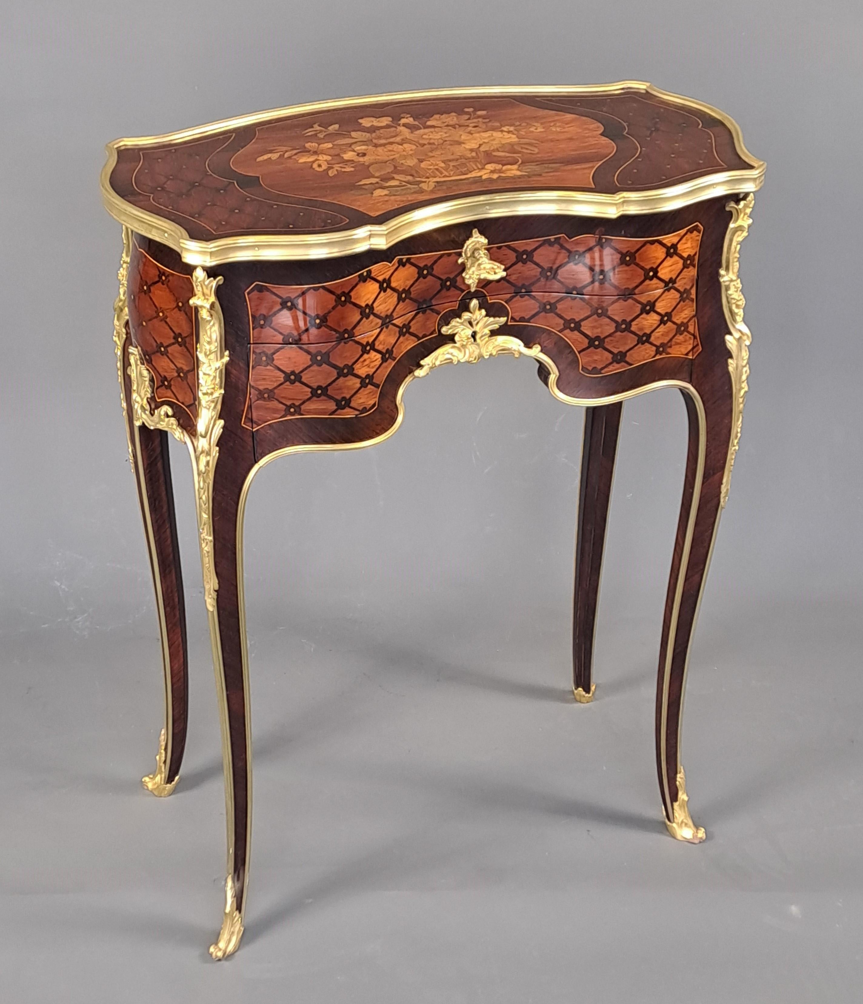 FRANÇOIS LINKE (1855-1946)

mall kidney-shaped table in marquetry of grids and quartefeuilles in amaranth reserves, on the top a magnificent flowered basket in fine marquetry. It opens with a flap top revealing a beautiful compartmentalized interior