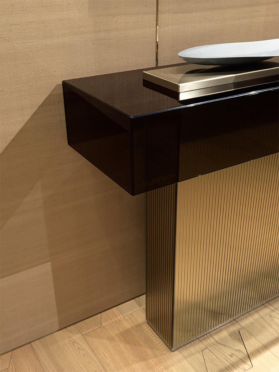 Tavolo Console Centro Townes con 2 strutture di base
in uno specchio bronzato con scanalature e ricoperto di Up & Up
in acciaio con finitura satinata. Struttura del piano del tavolo consolle in
vetro smocked, spessore 8 mm.
dimensioni delle basi:
A/