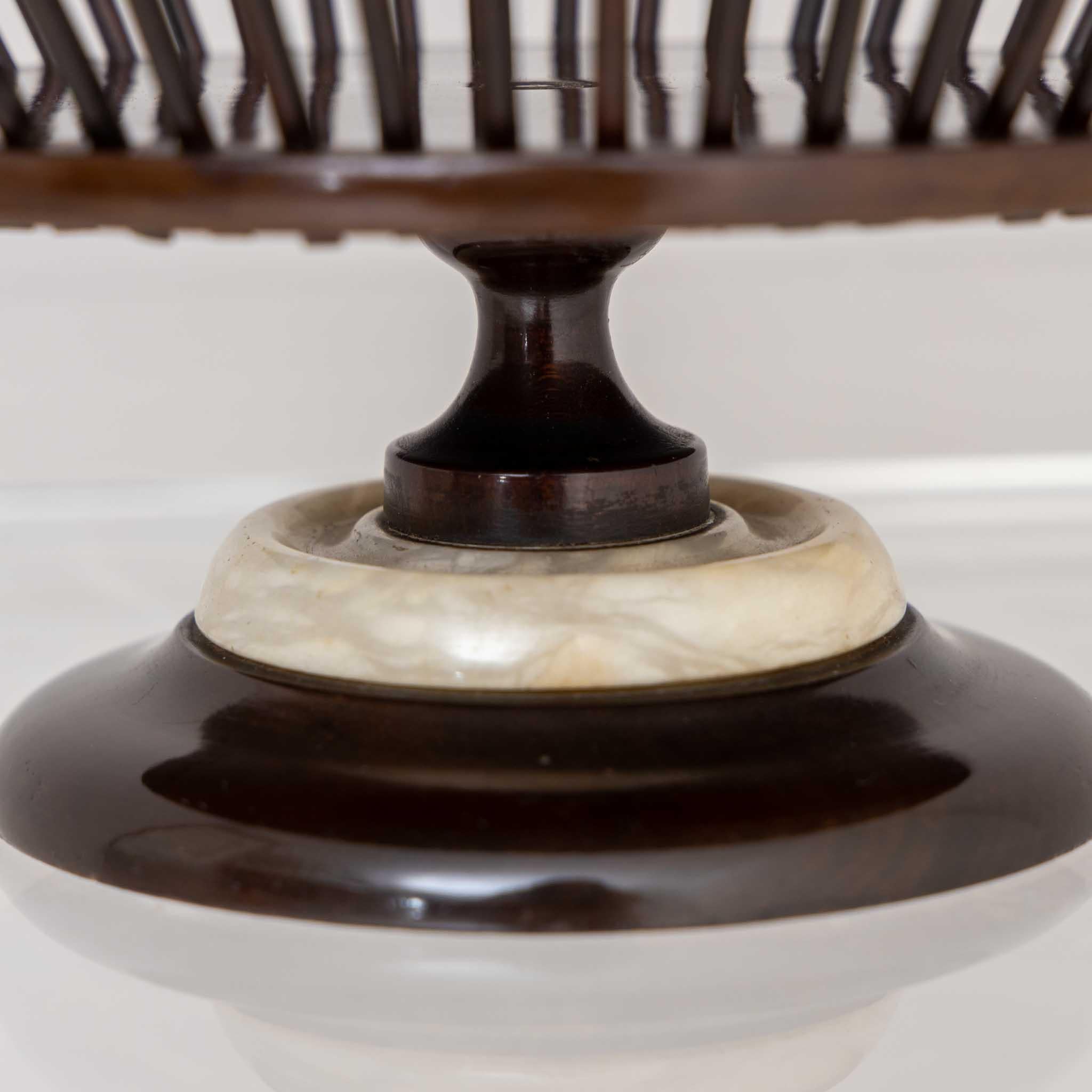 Small centerpiece with balustered base with stone ring and basket top made of dark stained wood. A ball of wool was placed in the center and the strings pulled through between the slats to spun yarn. 