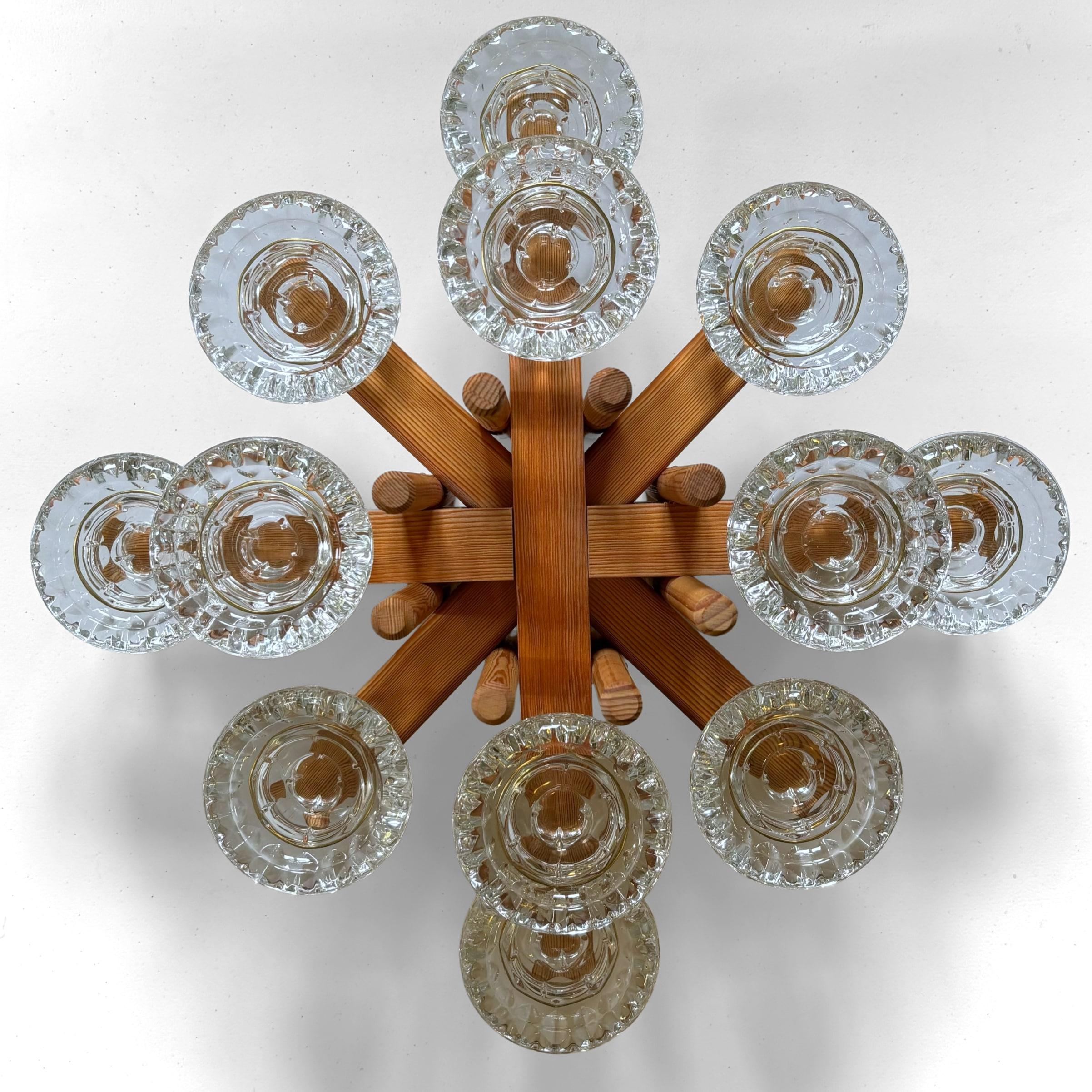 A magnificent, large modernist table centerpiece in the form of a pinewood candelabra, featuring twelve glass candleholders secured by brass rings. It can accommodate tea lights, pillar candles, or taper candles. Crafted from solid Swedish pine by