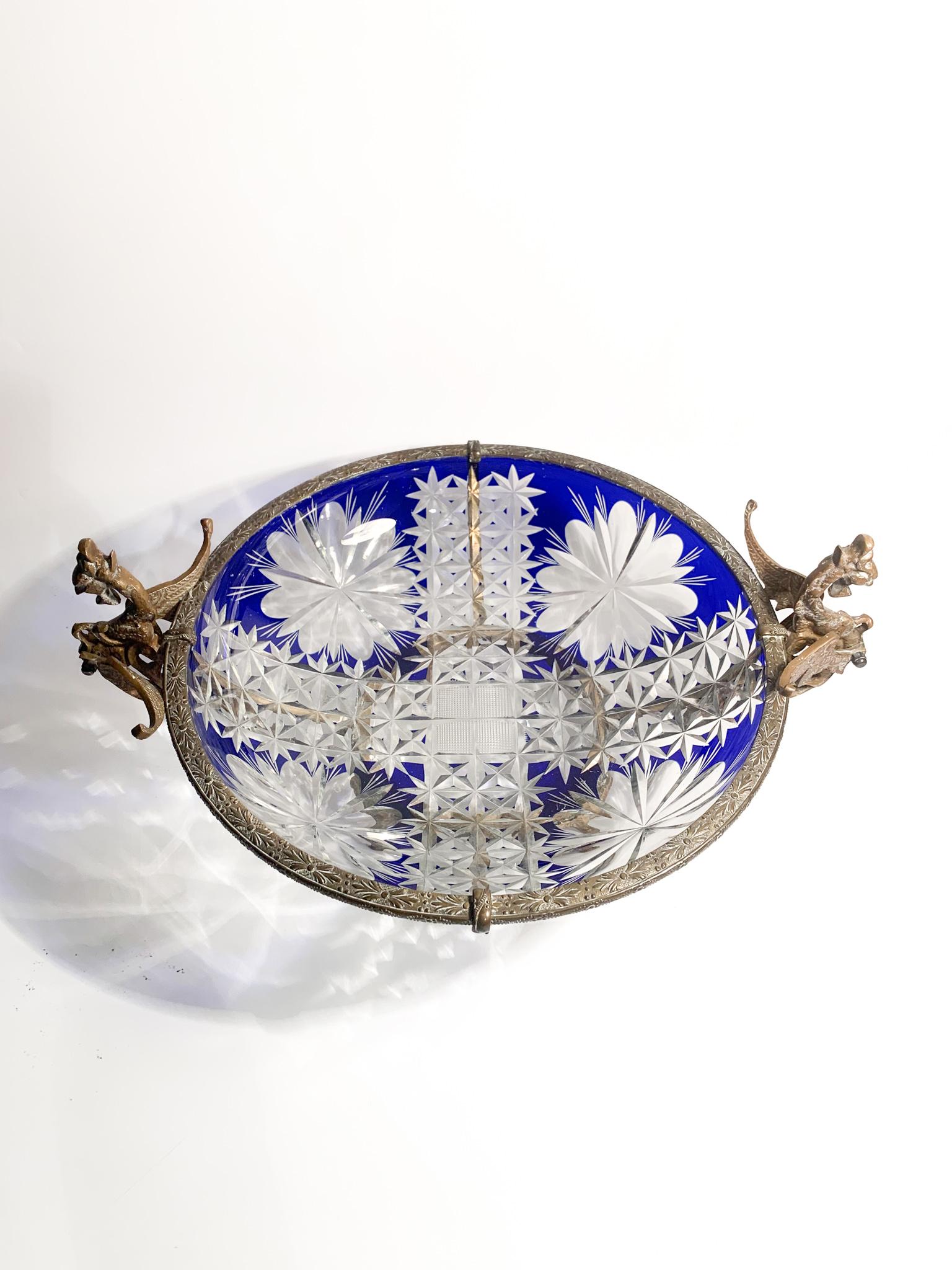 Centerpiece in transparent and blue Bohemian crystal and worked bronze, made in the early 20th century

Ø 39 cm Ø 30 cm h 18 cm

The Bohemian crystal is a decorative glass produced since the 18th century in Bohemia. This land is famous for the